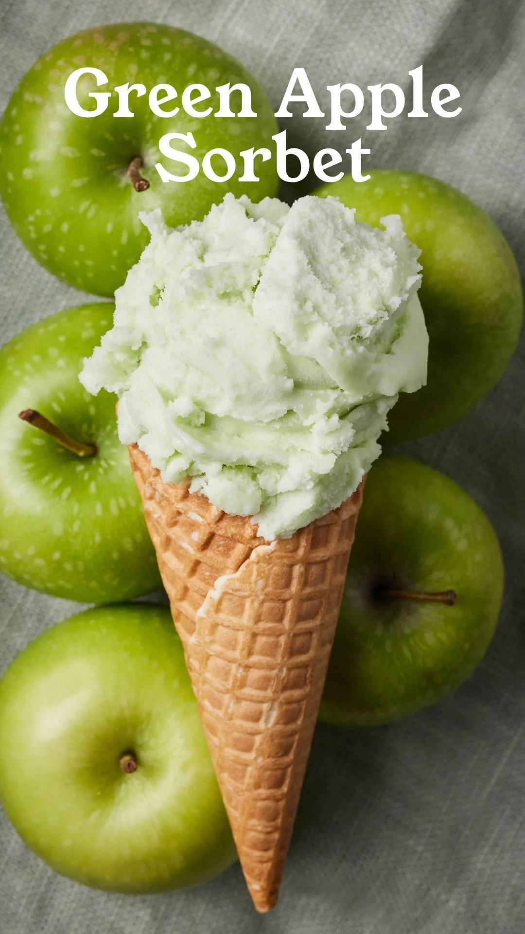 Green apple sorbet in a cone with green apples in the background.