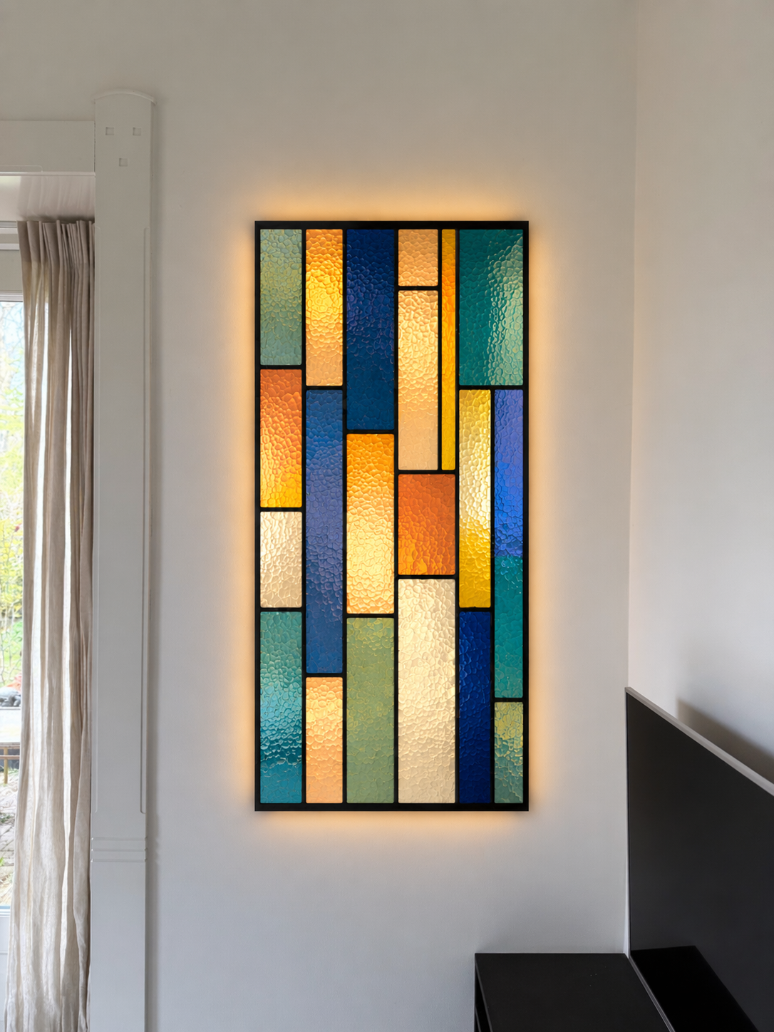 Gekleurde glasraam met abstract patroon en achtergrondverlichting in een witte muur.