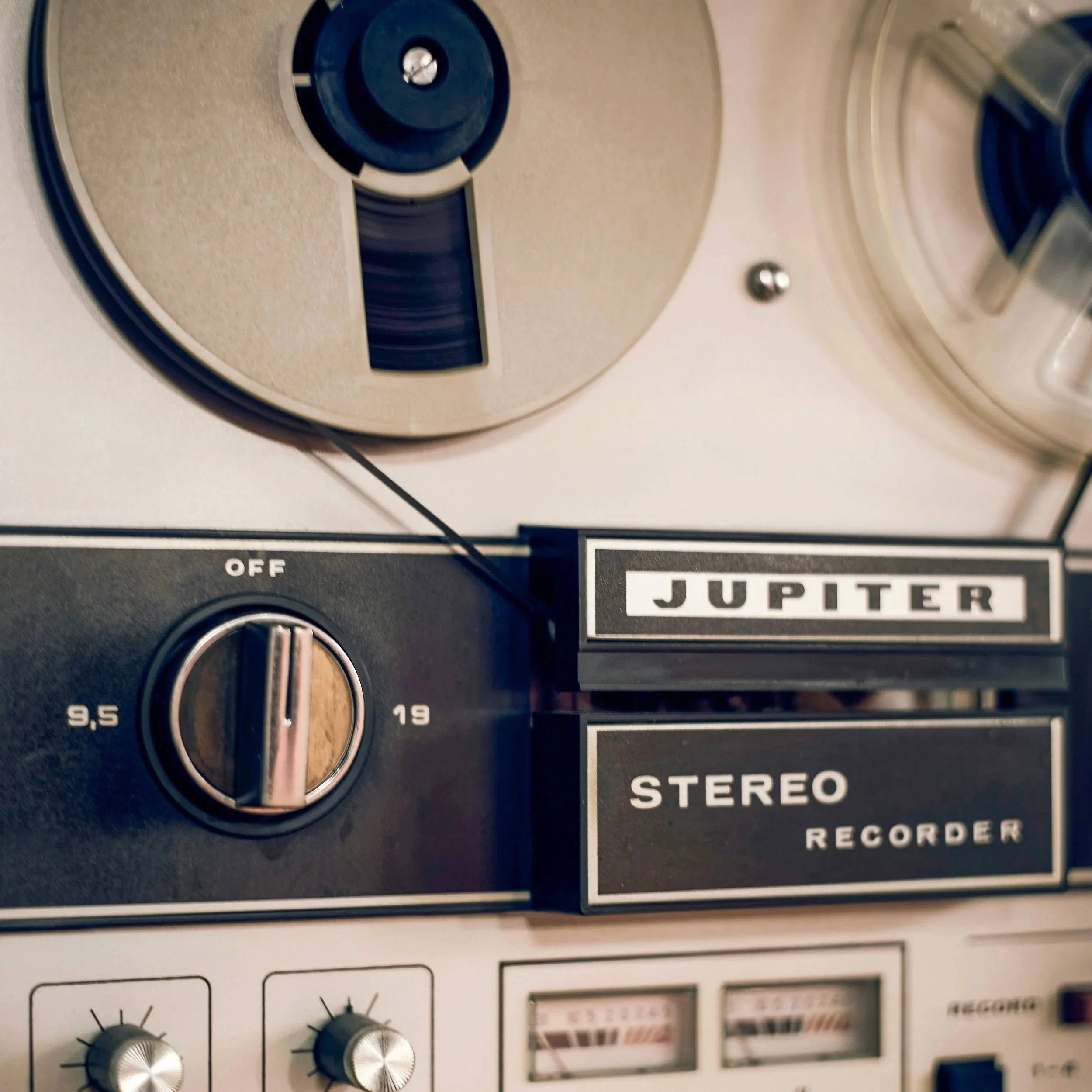 Close-up of a vintage stereo record player with knobs and switches, labeled 'Jupiter,' 'stereo,' and 'record'.