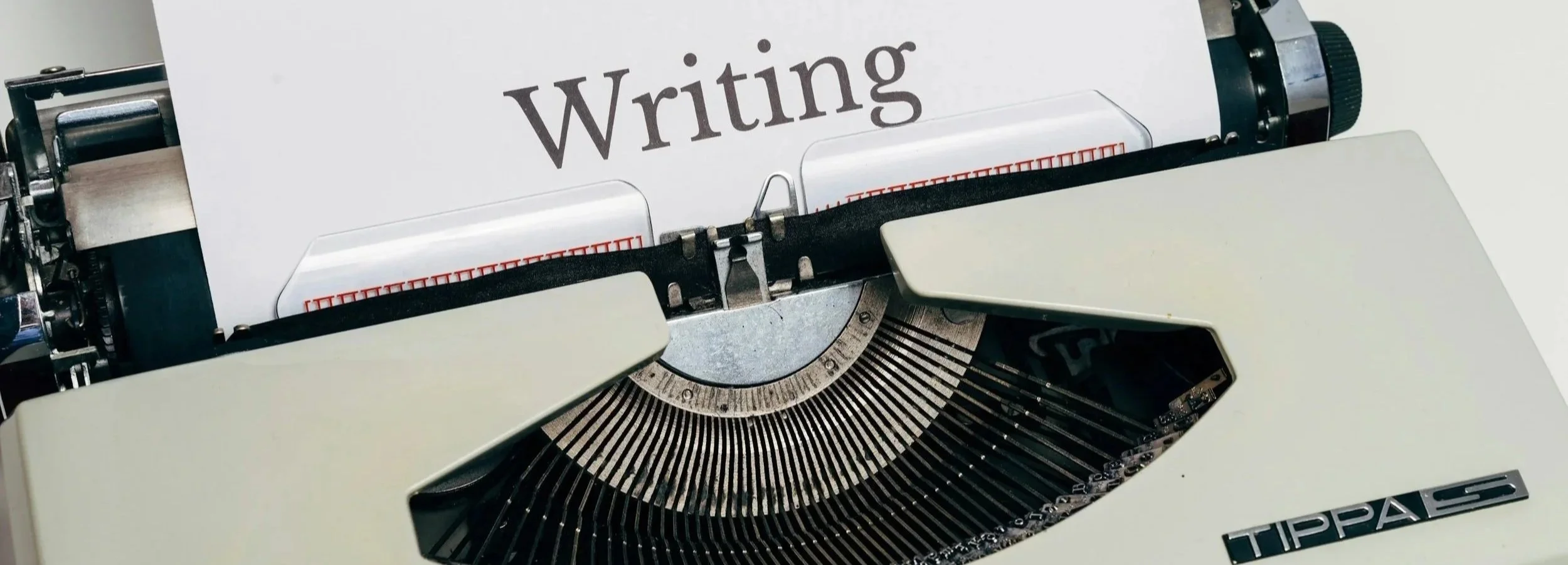 A typewriter with a sheet of paper that has the word 'Writing' typed on it.