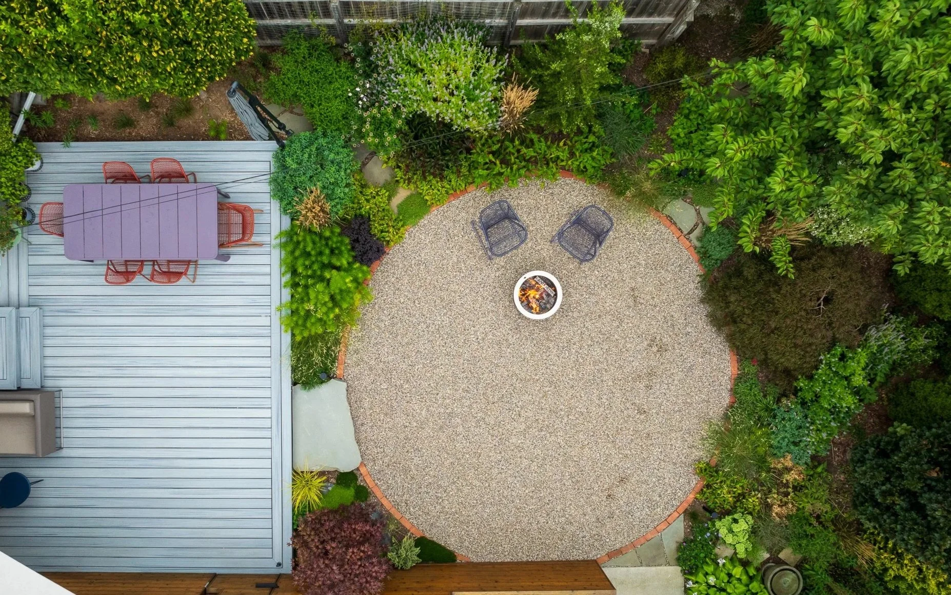 Award-winning naturalistic backyard landscape design with circular gravel patio, native plantings, and modern outdoor living space in Ann Arbor, Michigan.