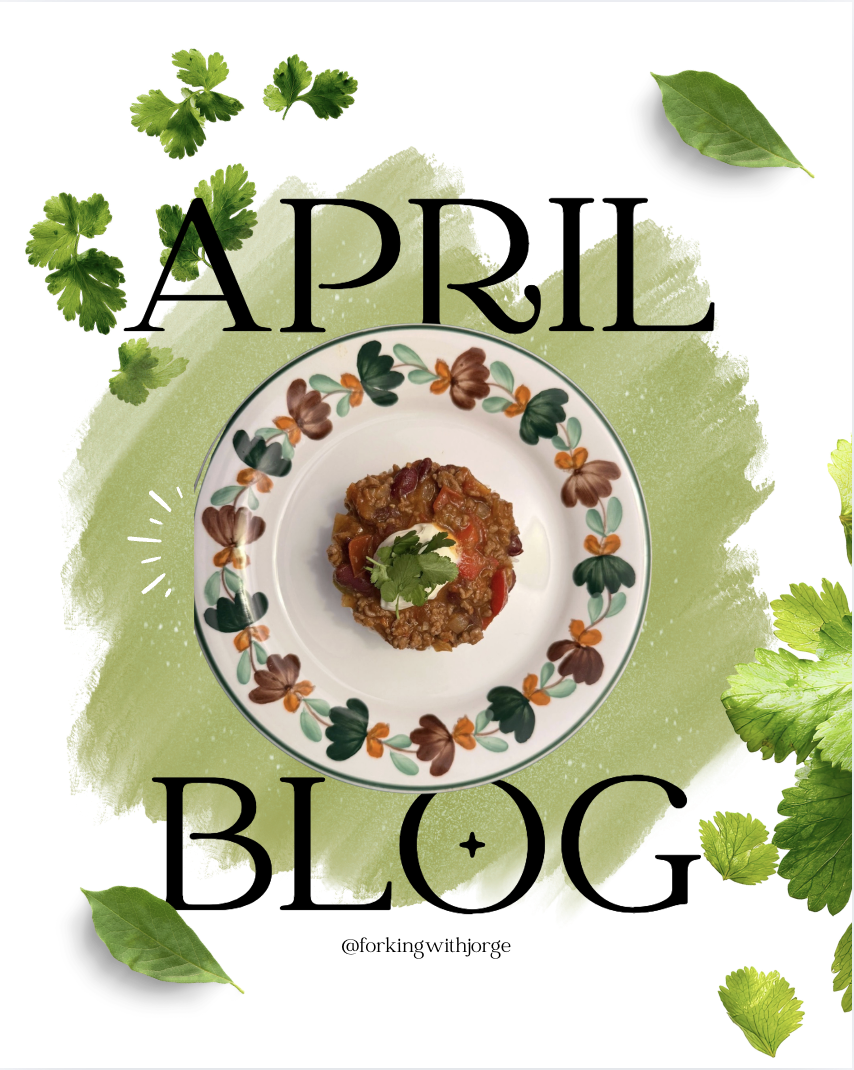 A plate with food on it, surrounded by green herbs, with the text 'April Blog' and the handle '@forkingwithjorge' in the background.