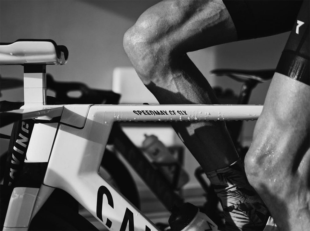 Close-up of a Jan Frodeno's leg and Canyon racing bike, emphasising the pedal area, in black and white.