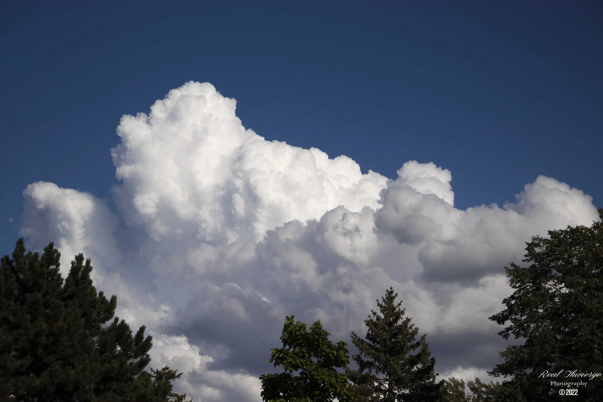 Large white fluffy cumulus clouds in Pierrefonds, Quebec - sky and nature photography by Tibber's Photography