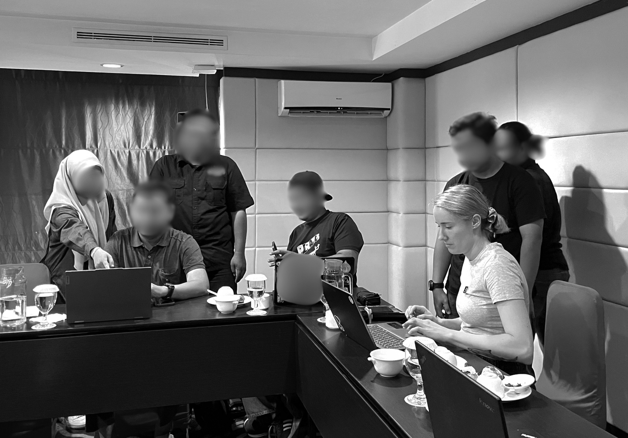 Grayscale photograph of the Langland Conservation team conducting specialized investigative training with laptops for frontline NGO partners.