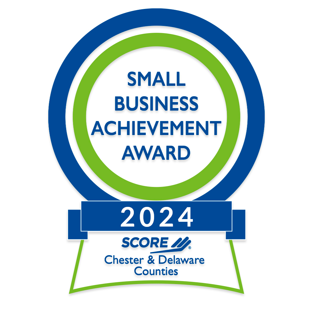 A badge or award graphic for the Small Business Achievement Award 2024, presented by SCORE for Chester & Delaware Counties. The badge features blue and green colors with a circular design and text indicating the award and year.