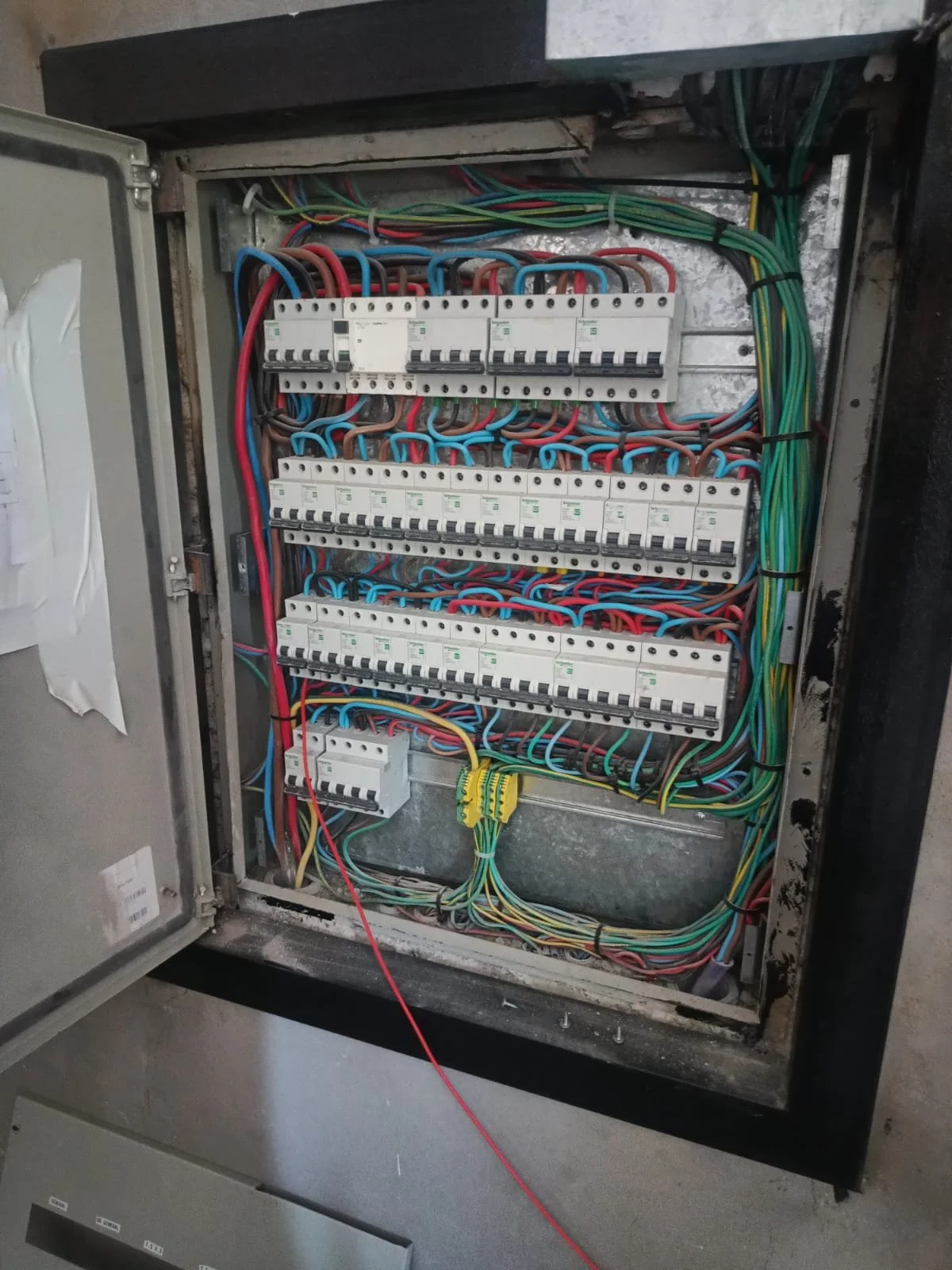 Tablero de distribución eléctrica con cables de diferentes colores y fusibles.