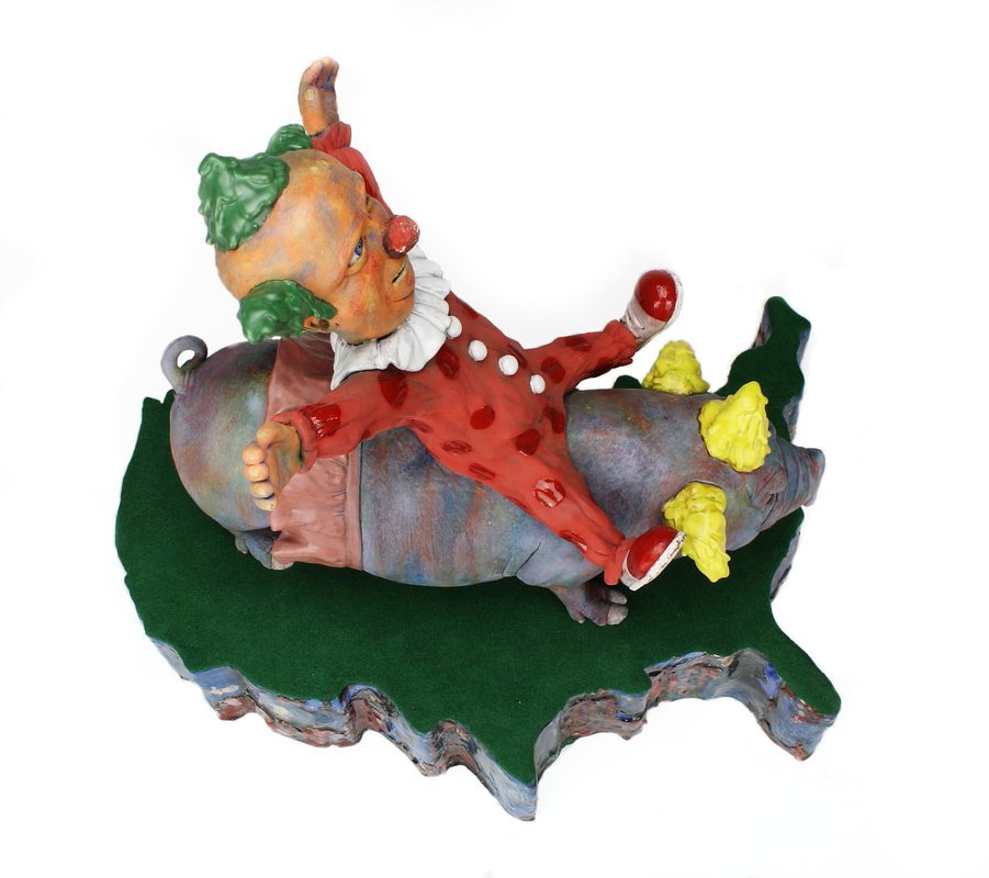 Clay sculpture of a clown with orange face, green hair, and red costume with heart patterns, lying on a purple object on a green oval base.