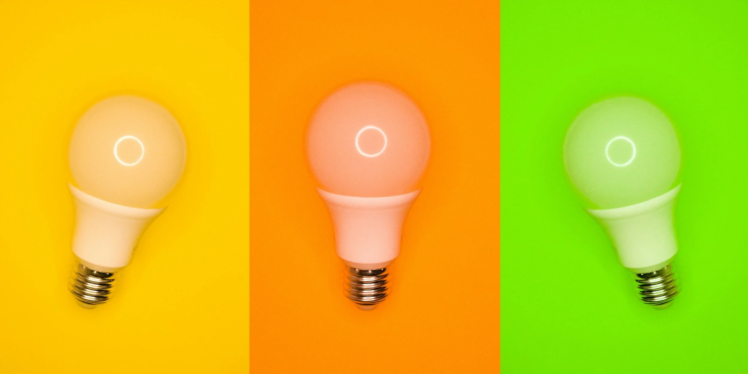 Tres bombillas con diferentes colores de fondo y luz encendida