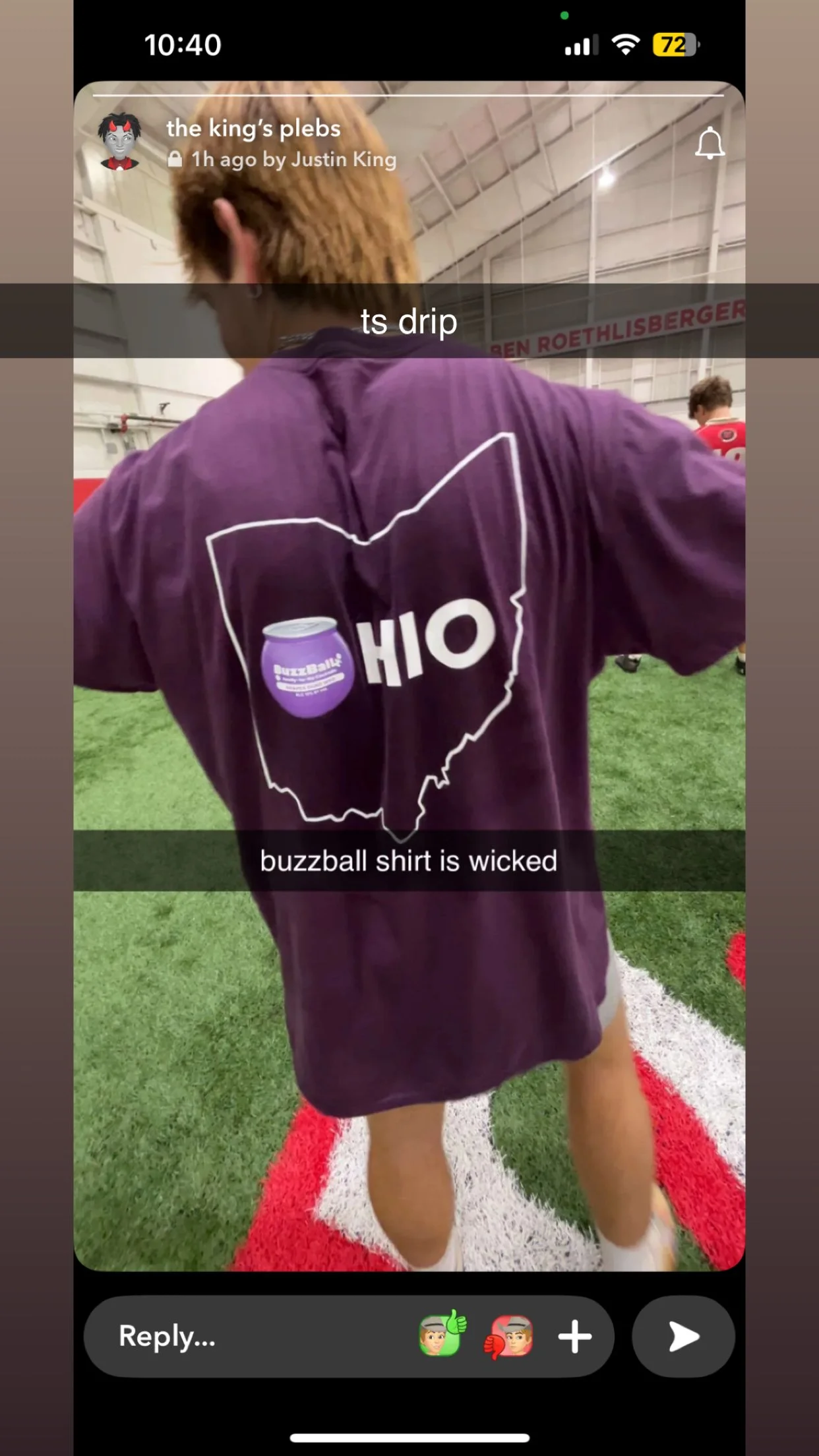 A person wearing a purple BuzzBall shirt standing on a football field with a red and white yard line. The shirt has an outline of Ohio with a BuzzBall can inside and the word 'OHIO' partially visible.