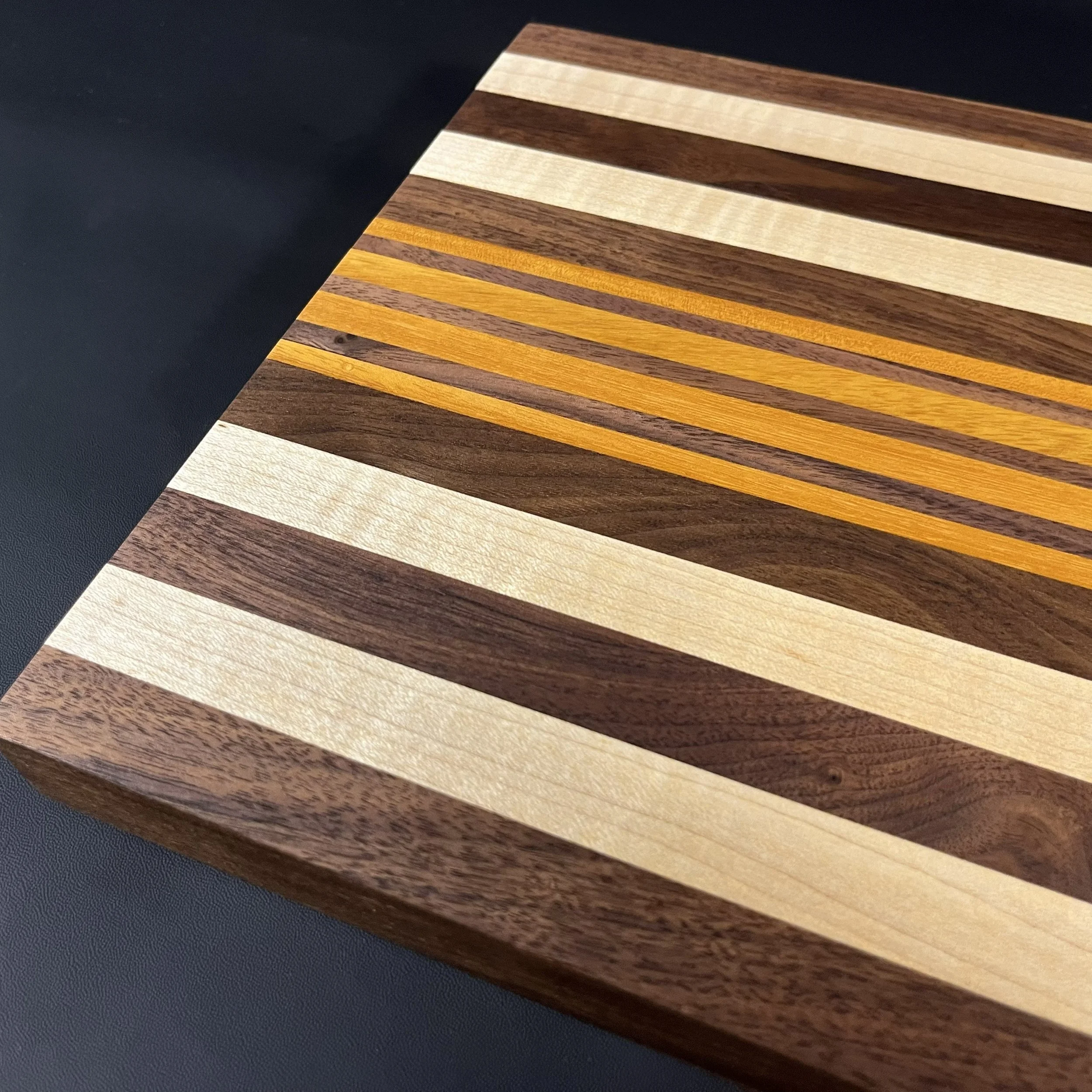 The Kickapoo cutting board with walnut and highlights of maple and Osage orange.