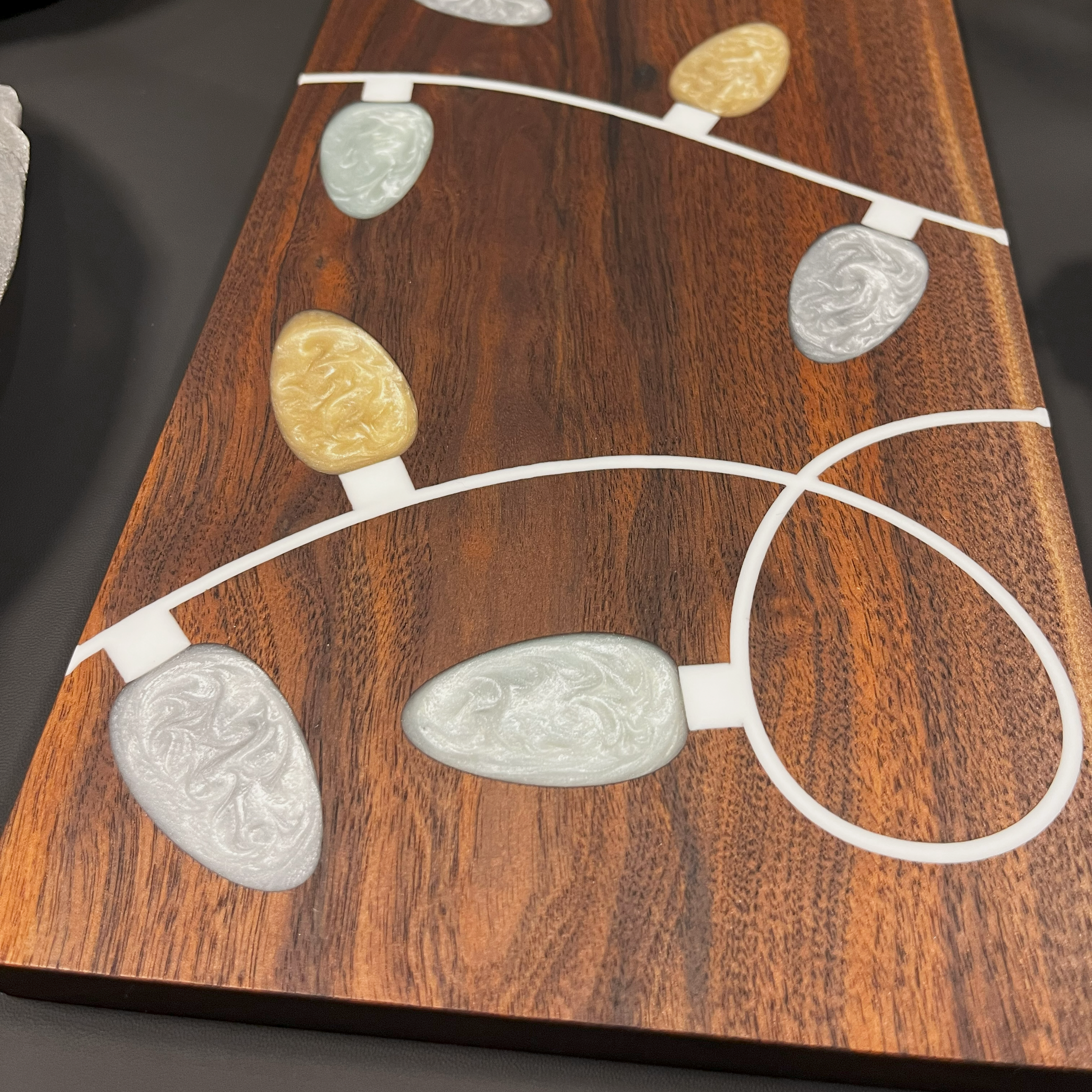 Close up of Christmas tree bulbs on rich walnut wood.