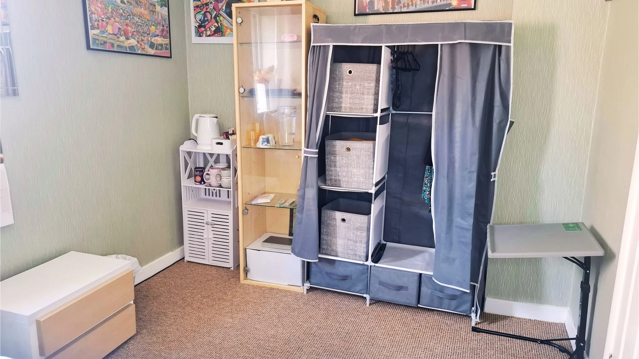Room with a bed, nightstand, lamp, and a fabric storage unit.
