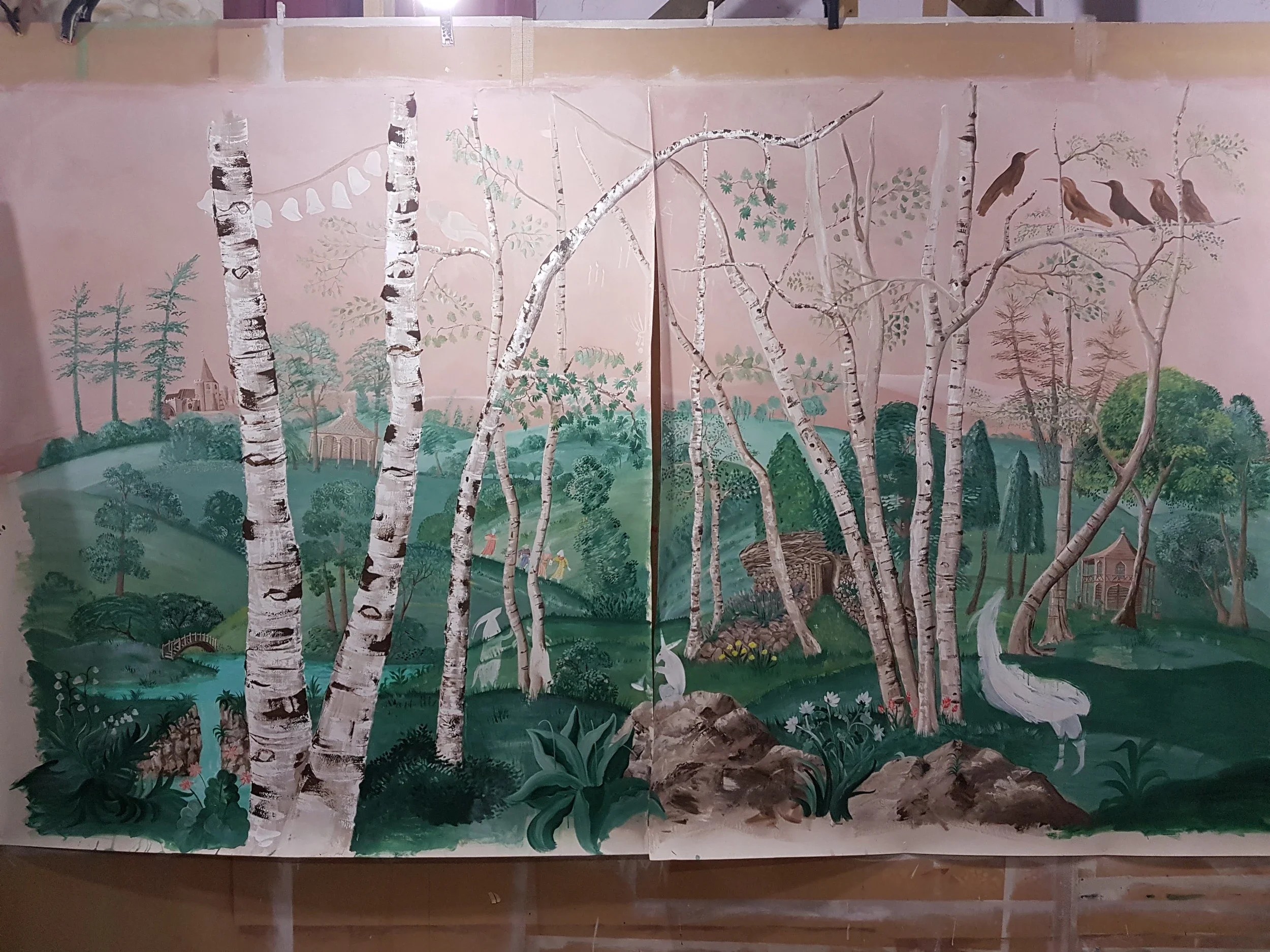 Work in progress at Melissa White's Hastings studio. Lantern Parade wallpaper by Melissa White for Andrew Martin, detail showing figures carrying lanterns through silver birch woodland, developed in collaboration with Kit Kemp.