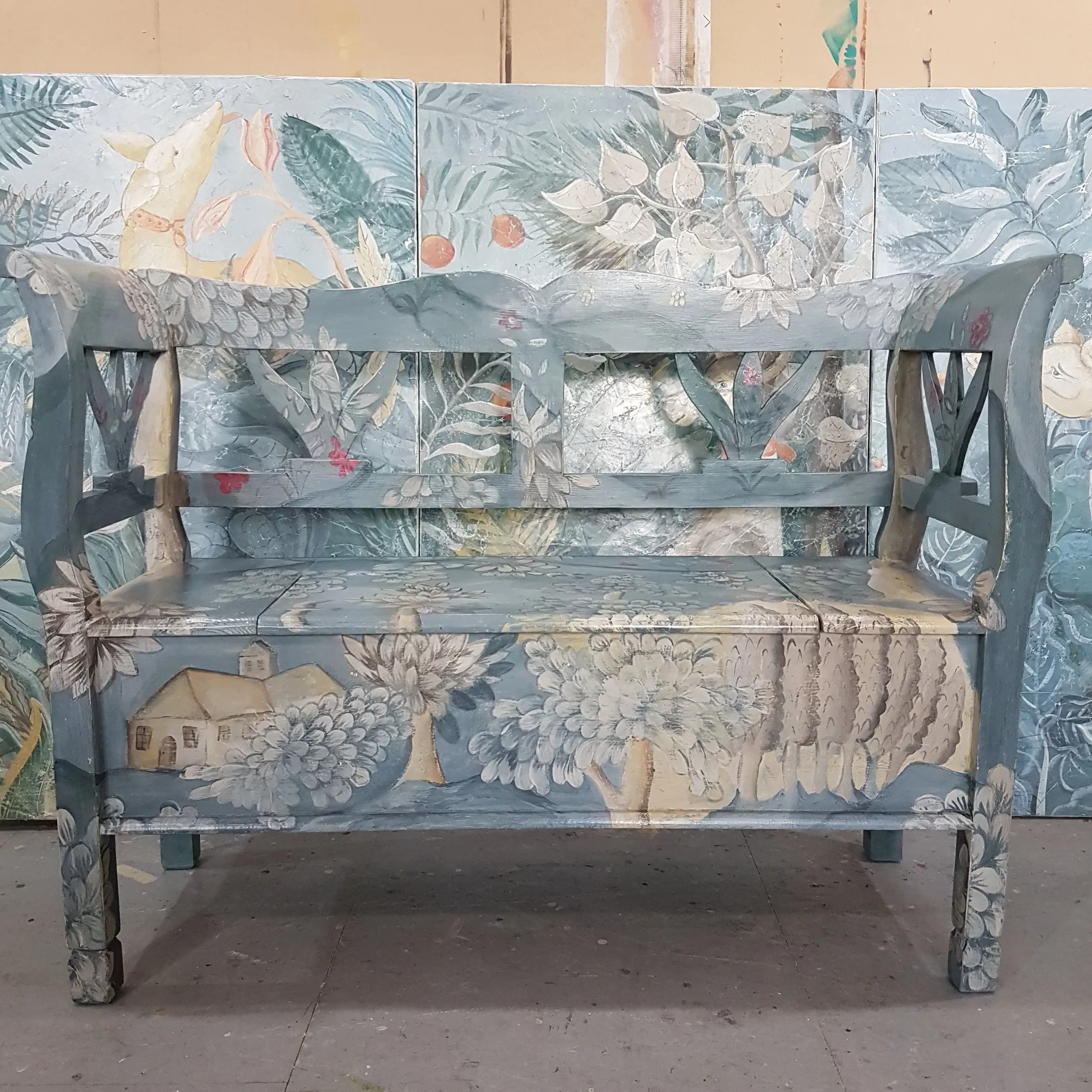 Hand-painted verdure bench by Melissa White, made for Kit Kemp's Drawing Room installation at Bergdorf Goodman, New York, 2019. Wrap-painted in a lush botanical design with Mythical Land mural visible in the background.