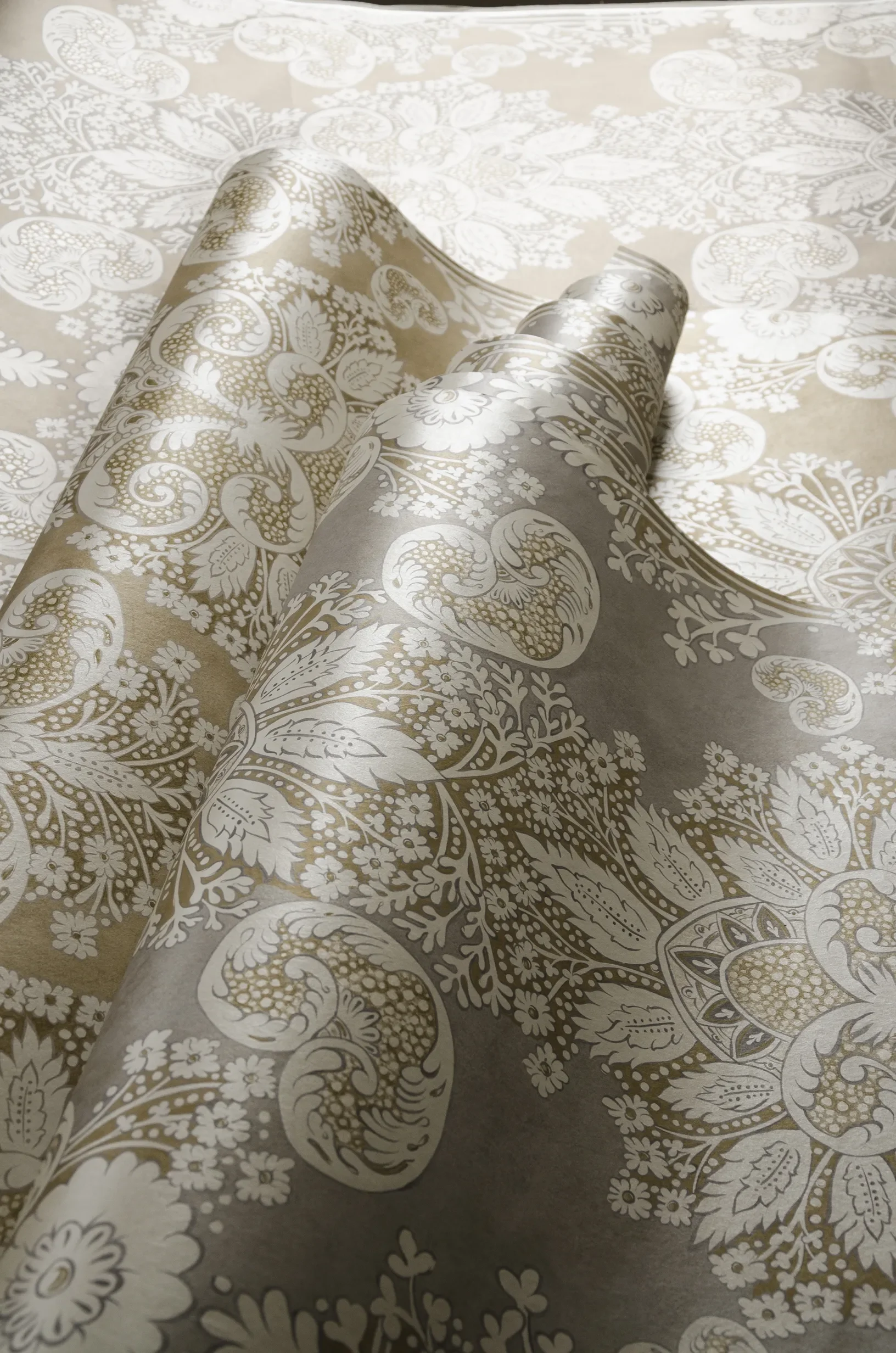 Close-up of an unfurling roll of Rococo wallpaper by Melissa White for Lewis & Wood.