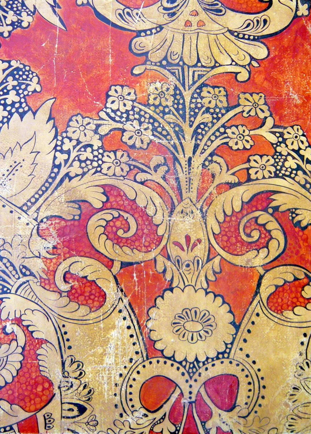 A detailed, vintage-style floral pattern with yellow and black outlines on a textured red and yellow background, featuring flowers, leaves, and swirling designs.