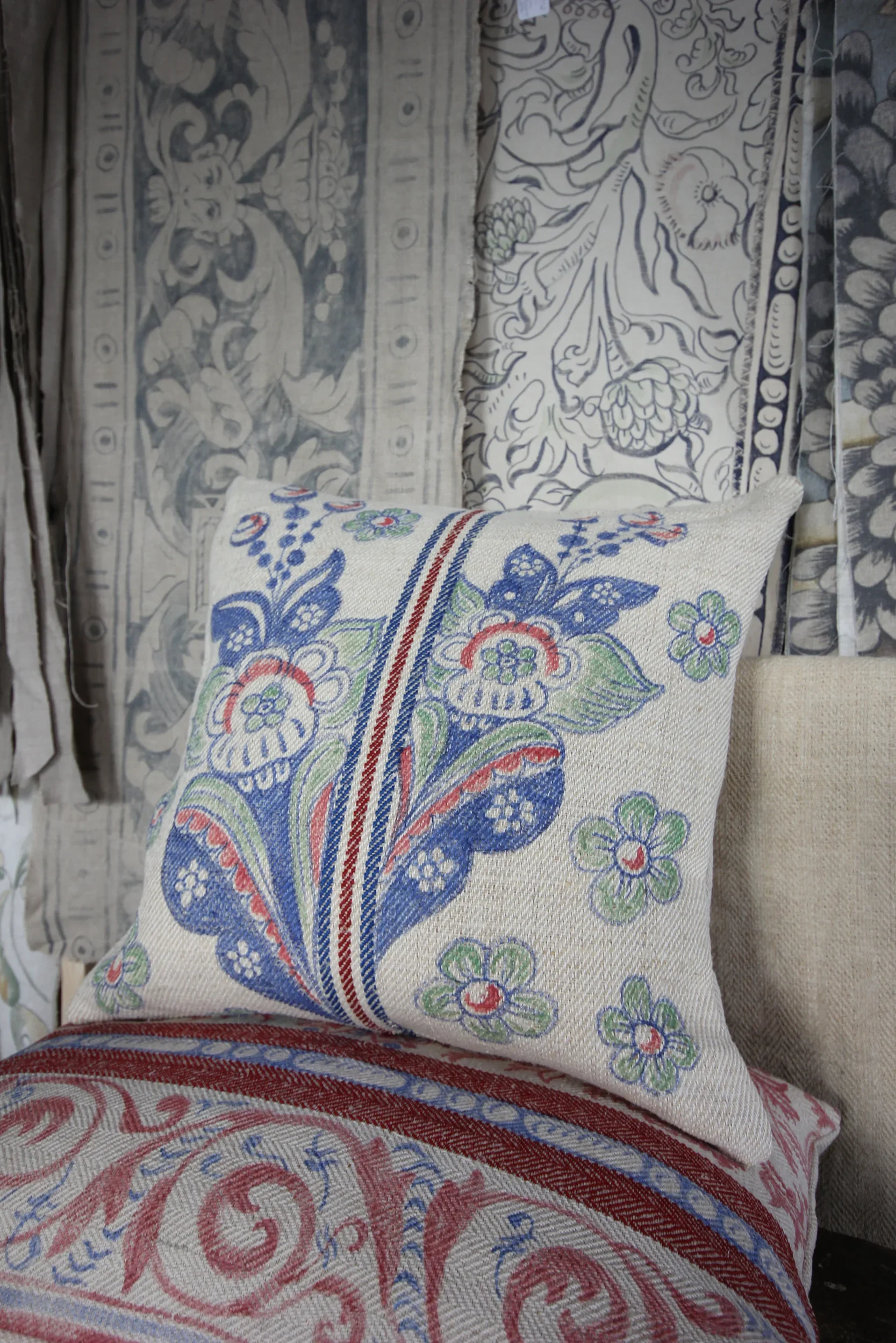 Hand-painted cushion by Melissa White for Le Bon Marché, Paris. Picture shows a blue and green stylised floral pattern.