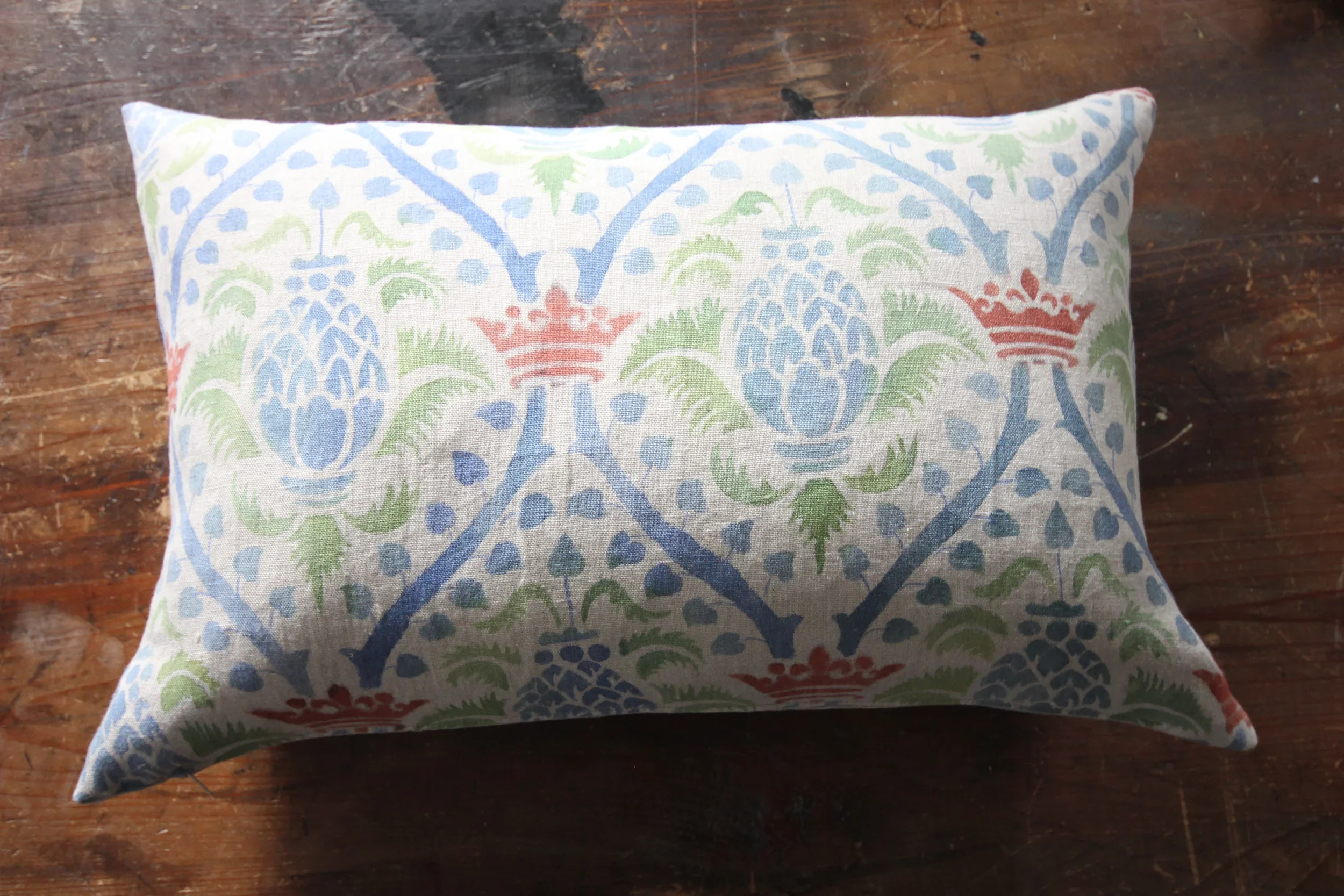 Decorative pillow by Melissa White for Le Bon Marché, Paris showing the royal pineapple in blue with green and red accents.
