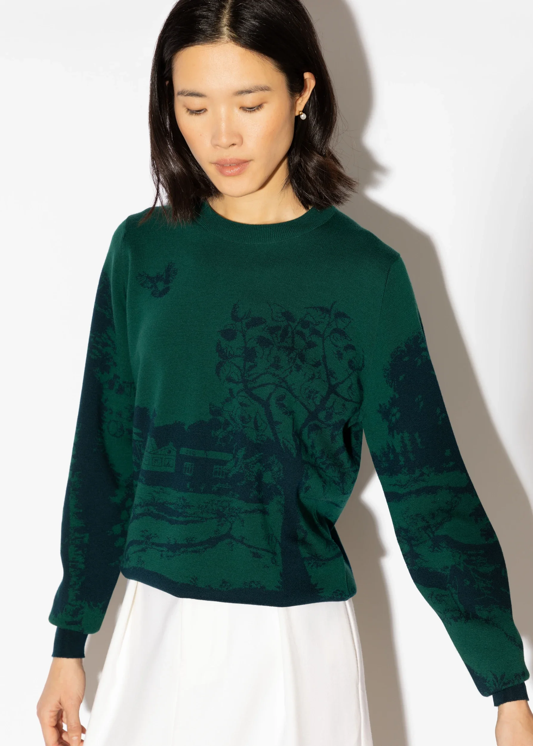 A model wears a green jumper stitched with the detail from Melissa White's collaboration with John Smedley on the occasion of their 240th anniversary.
