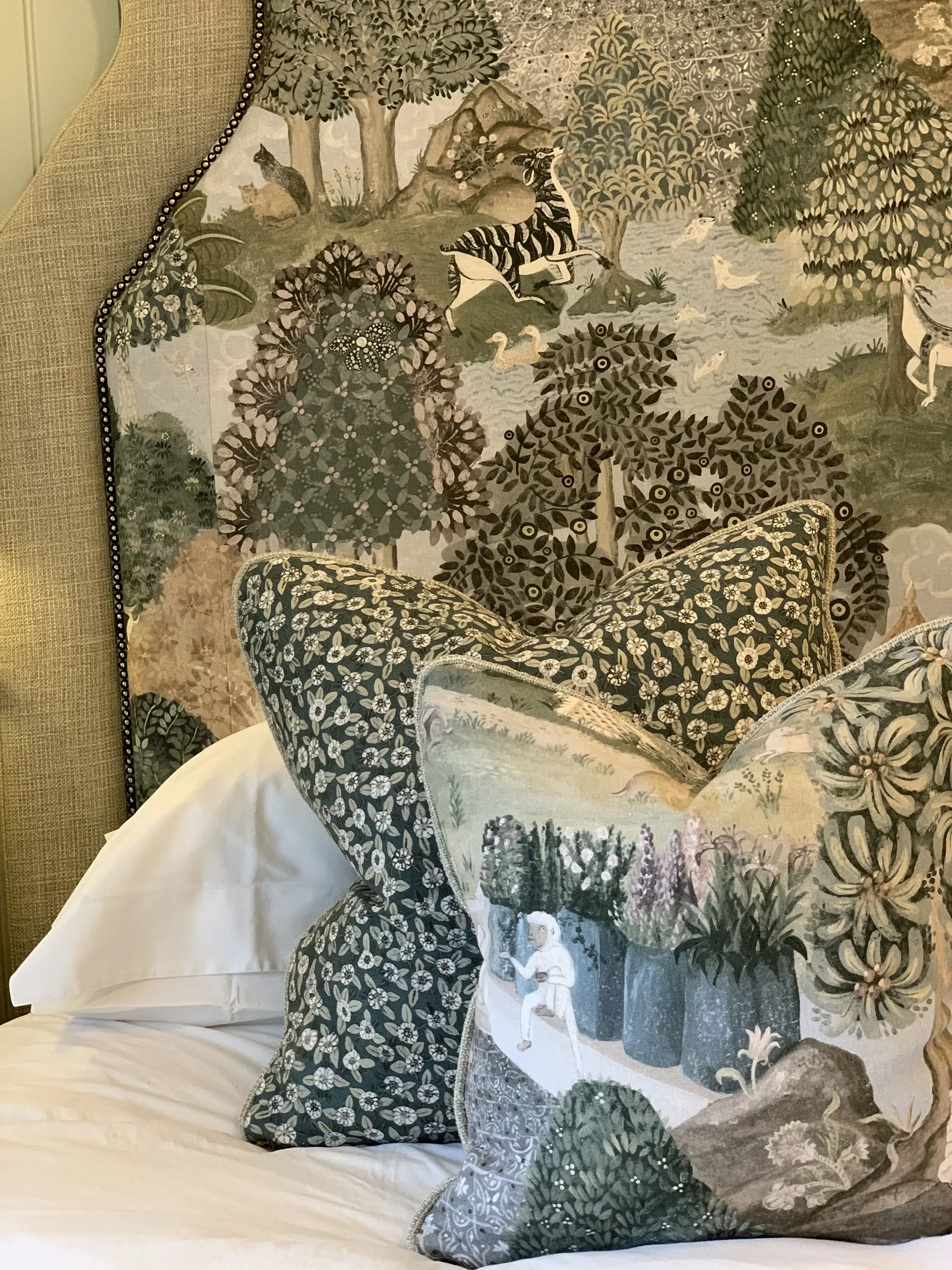 Emily's Garden wallpaper and complimentary cushions by Melissa White pictured on a bed.