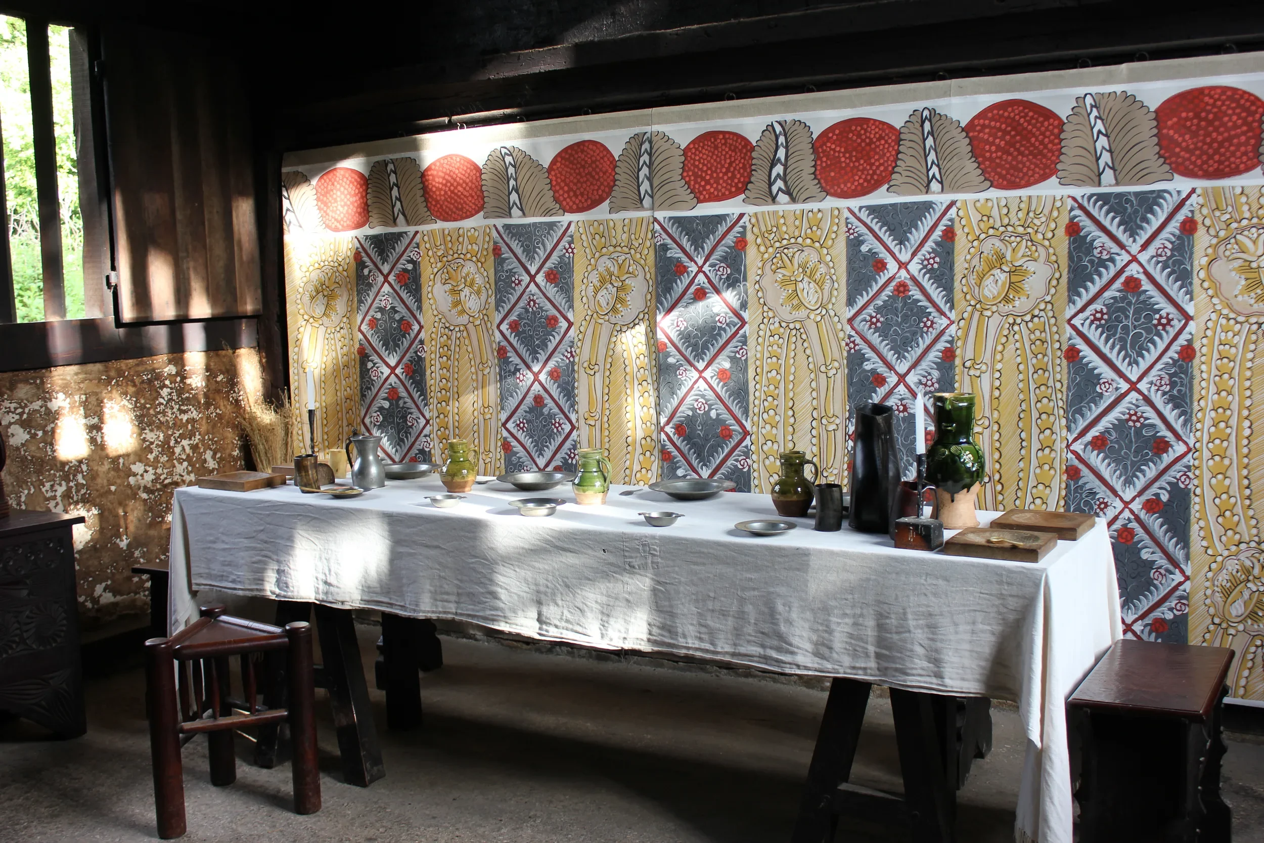 Bayleaf panel at the Weald and Downland museum, painted by Melissa White. Cloth is pictured in front of table set in Tudor style.
