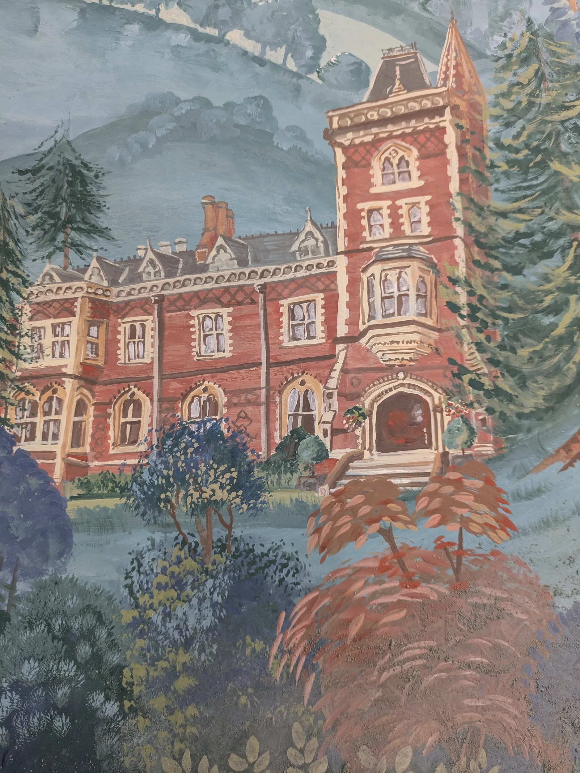 Painting of an old brick building with ornate windows, surrounded by trees and foliage, with mountains and a cloudy sky in the background.