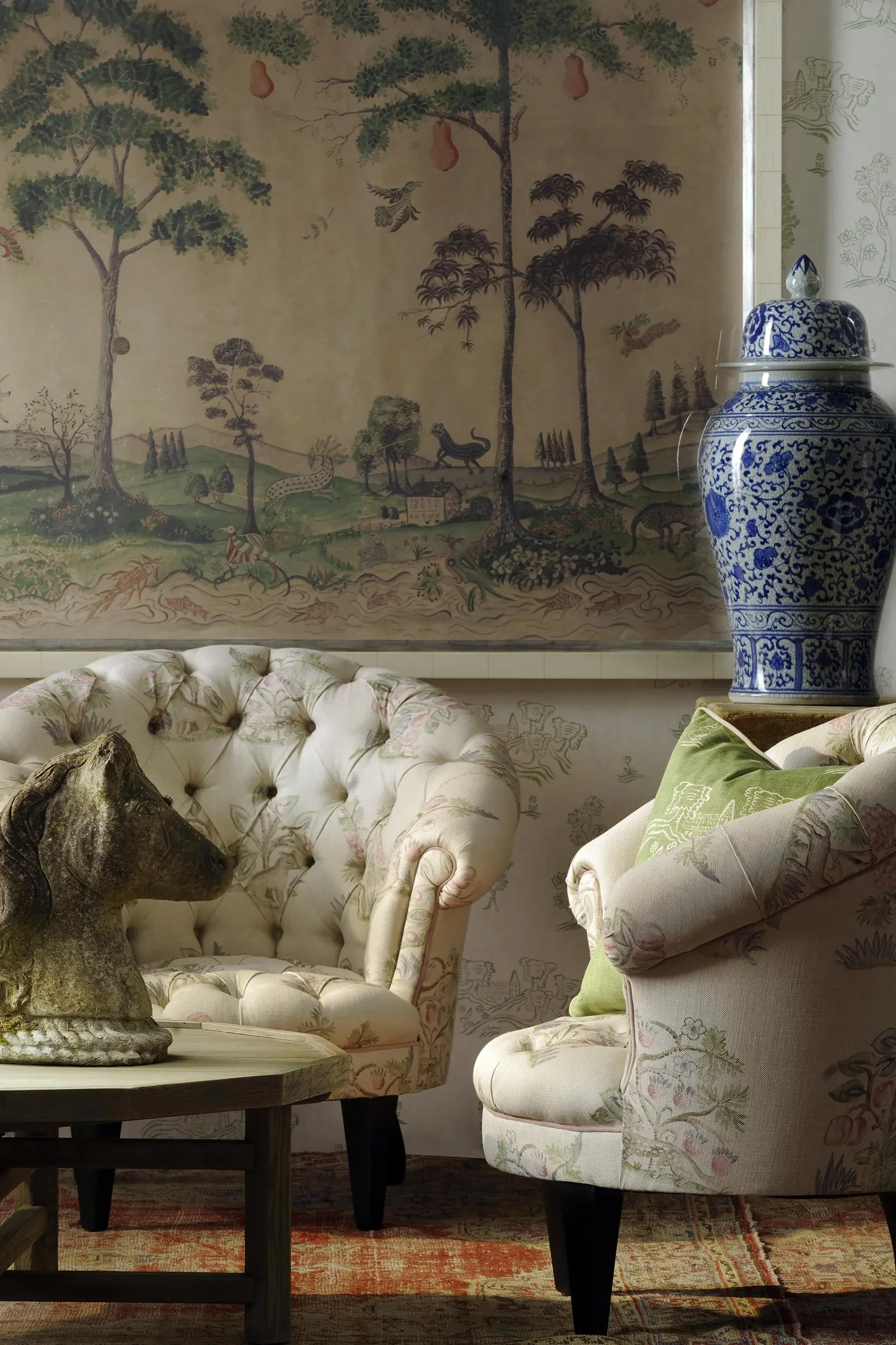 Mythical Land wallpaper by Melissa White for Kit Kemp and Andrew Martin pictured in a sitting room with two upholstered chairs.