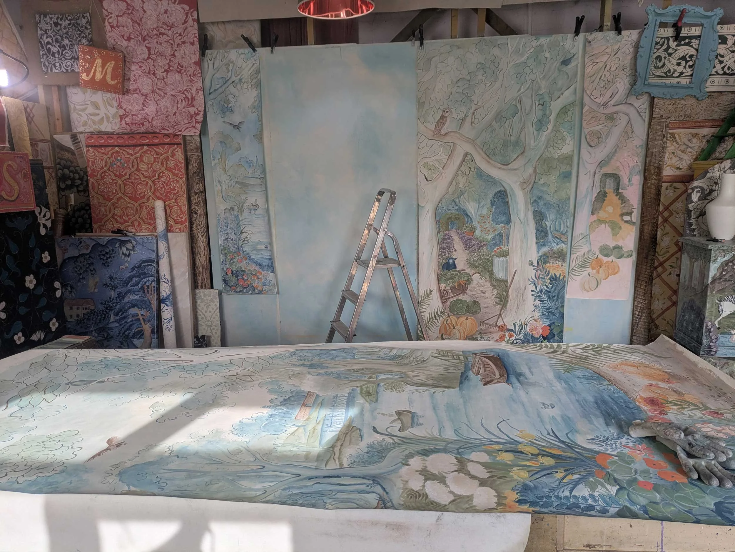 Melissa White’s studio featuring the original mural artwork on the walls and a hand-painted panel on the table.