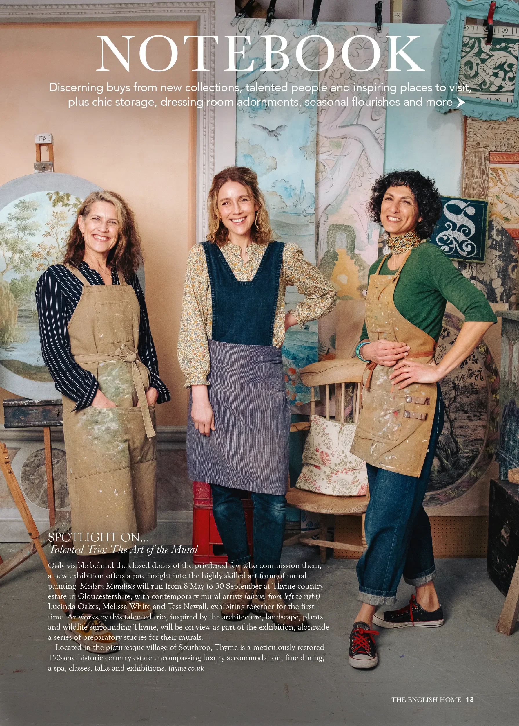 Photograph of three women standing in an art studio with paintings and tools behind them. The image is part of a magazine or brochure, with the title "NOTEBOOK" and text about an art exhibition in Gloucestershire featuring mural painting.