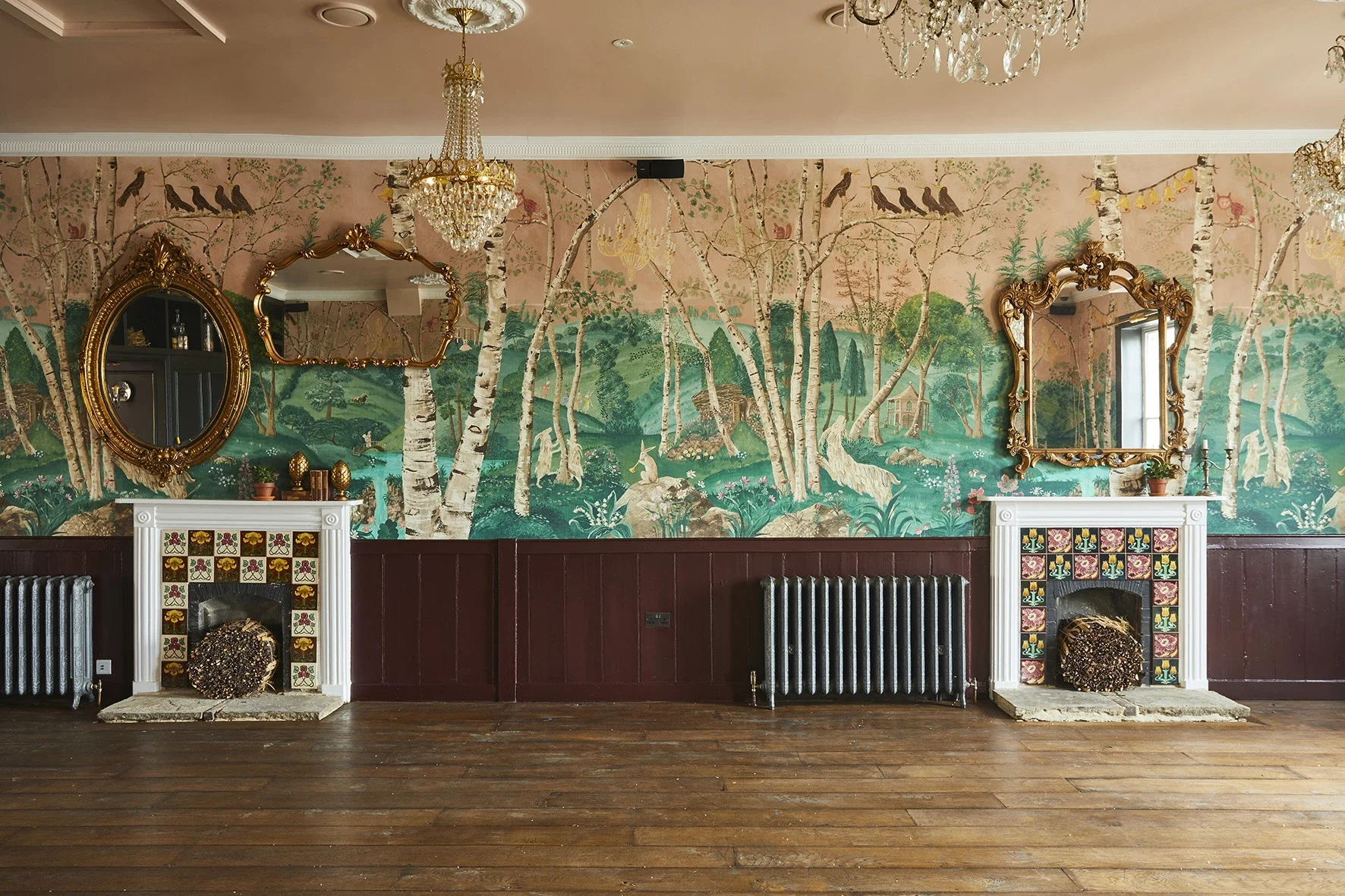 The Big Room at The Bell in Ticehurst, East Sussex, showing the bespoke scenic wallpaper by Melissa White, 2020. Hand-painted woodland landscape with silver birch trees.