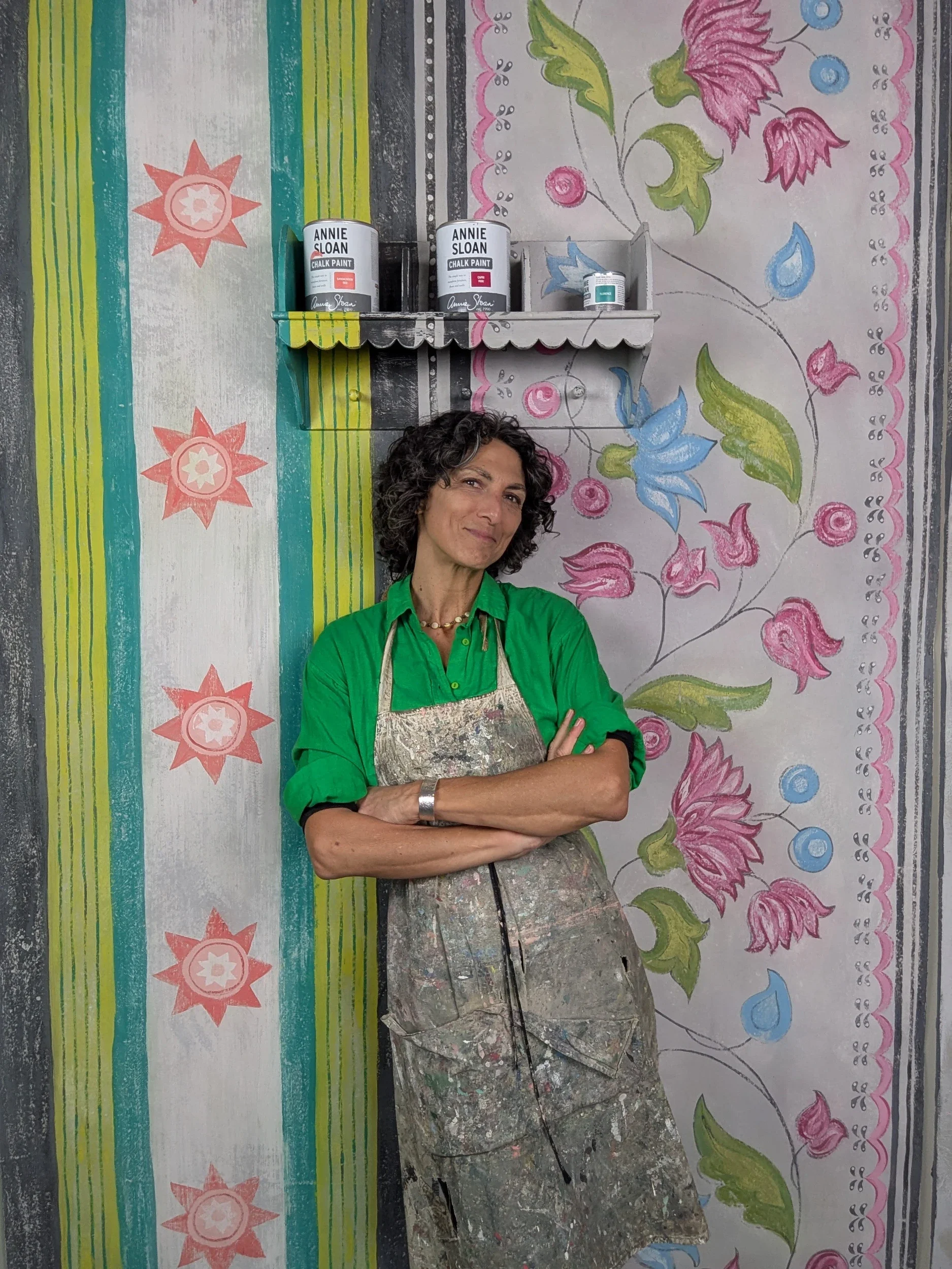 Melissa White is pictured in her apron in front of her Chalkhouse wall-painting, developed when Annie Sloan Painter in Residence.