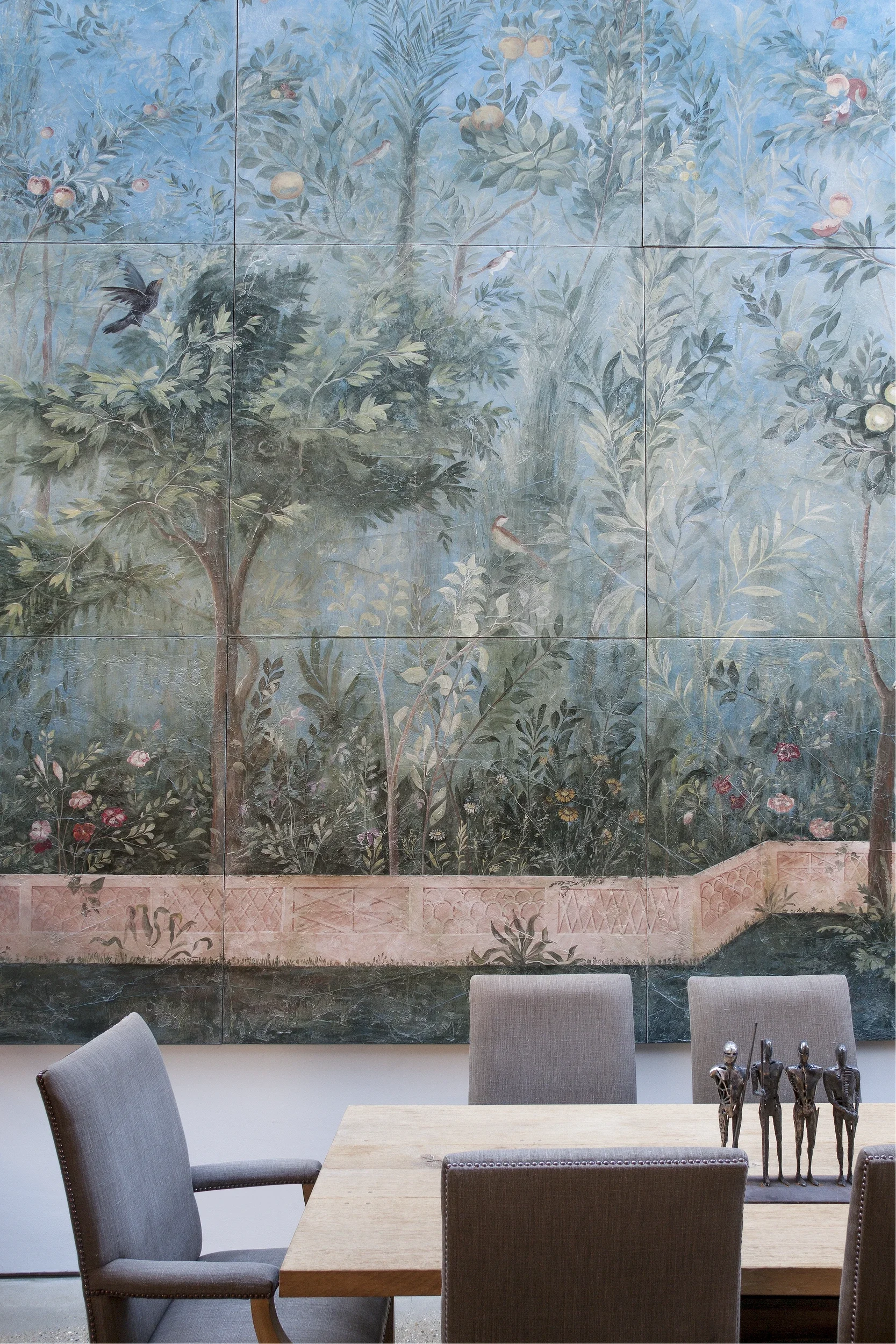 A dining room set against Melissa White's Villa of Livia fresco secco panelling.