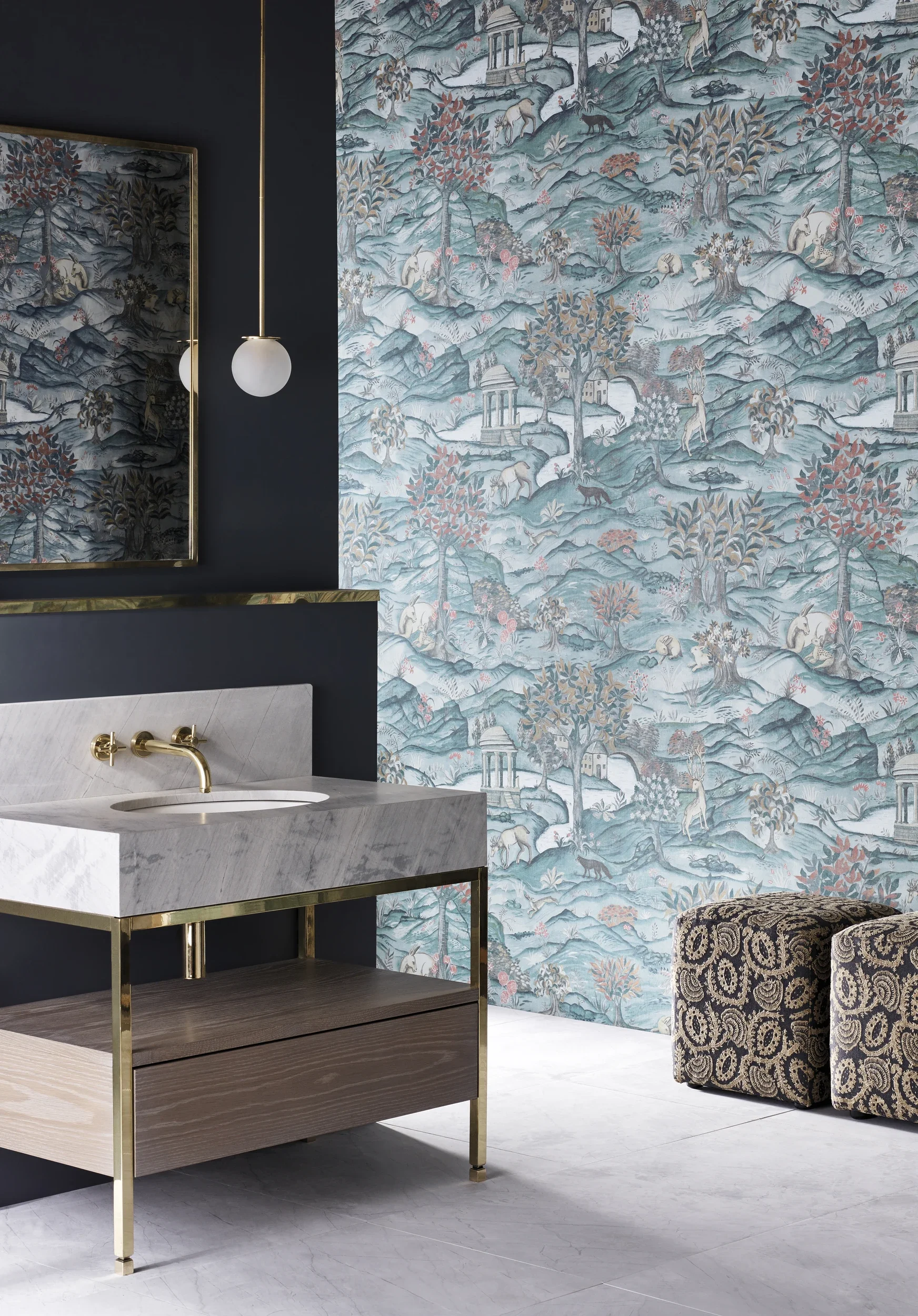 Interior view of a room with a marble vanity, a dark wall, and a large wallpaper mural depicting a landscape with trees, horses, and architectural structures. A mirror hangs on the wall, and a modern spherical wall sconce is present. There is also a patterned upholstered chair visible.