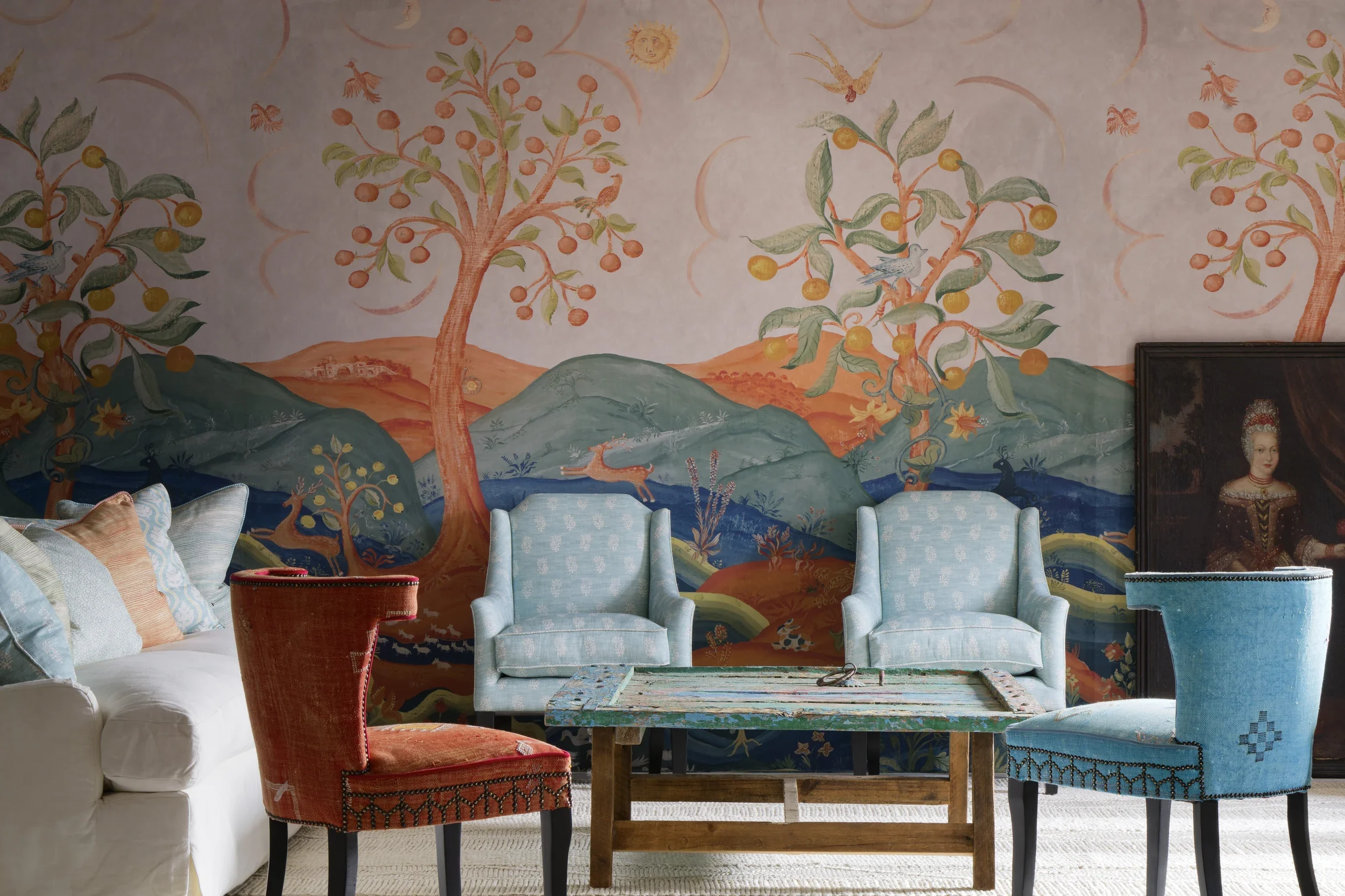 Rufus: Harvest Moon wallpaper by Melissa White for Andrew Martin, room shows four upholstered armchairs and an oil painting leaning against the wall.