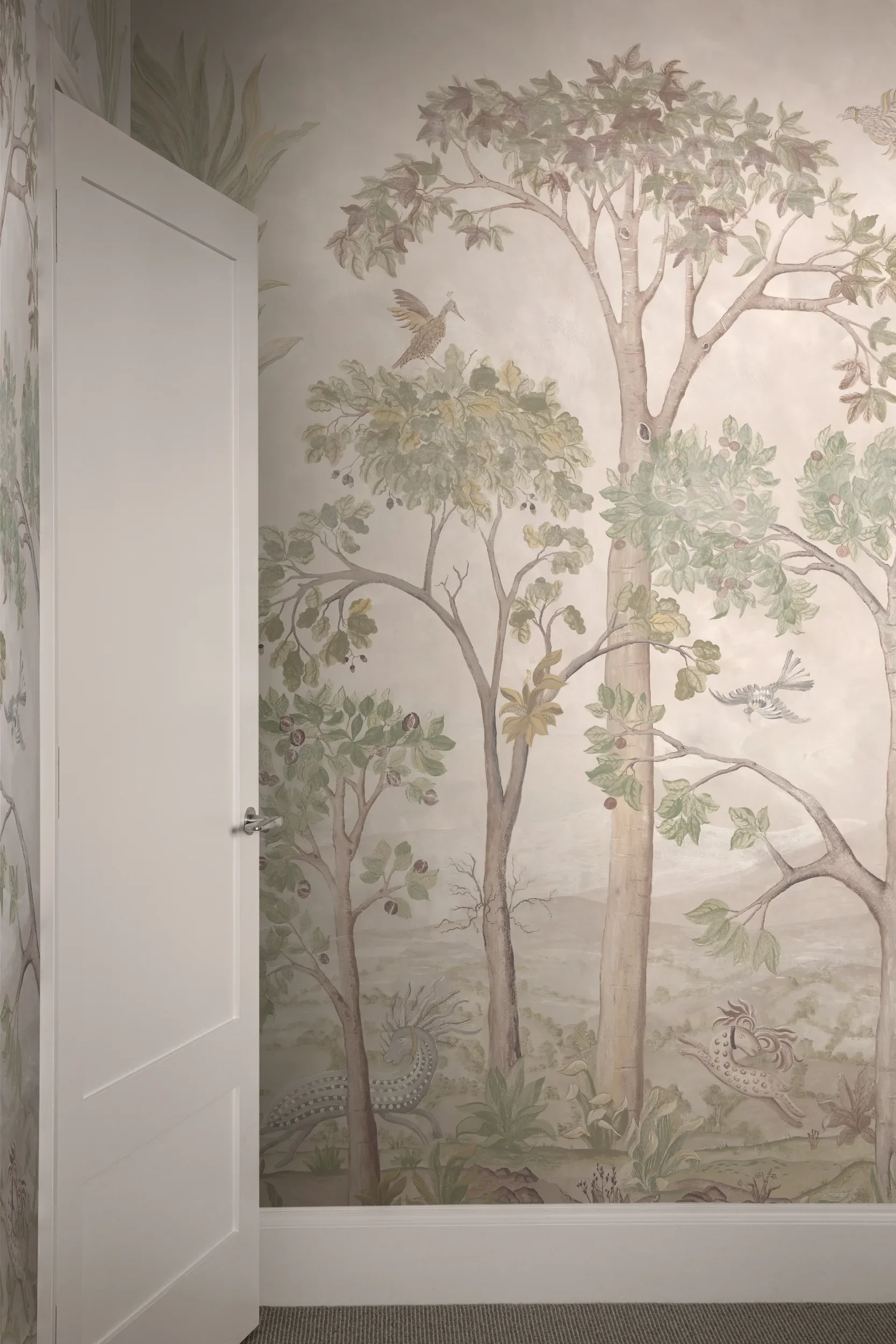 Tall Trees wallpaper by Melissa White for GP&J Baker, Kit Kemp Wallpaper collection, in the Sunset colourway. Wallpaper is shown with a partially open white door on the left side.