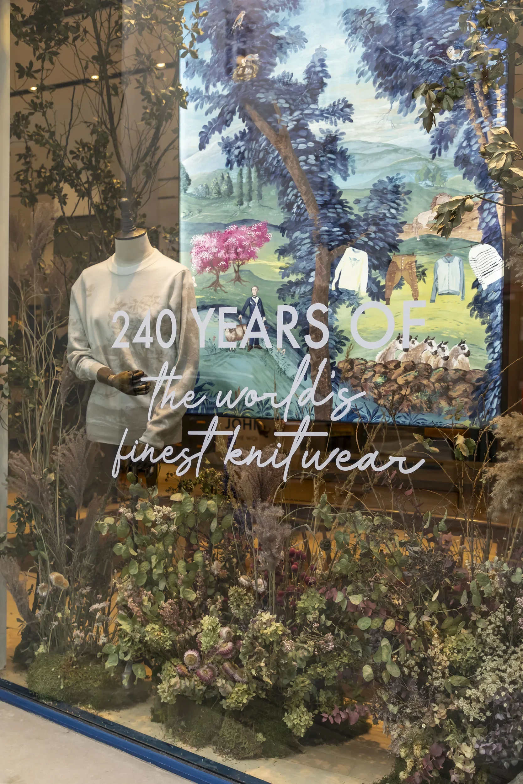 Shop window shows Melissa White's collaboration for John Smedley's 240th anniversary. Pictured is Melissa's large painting with clothes from the collaboration on mannequin in front.