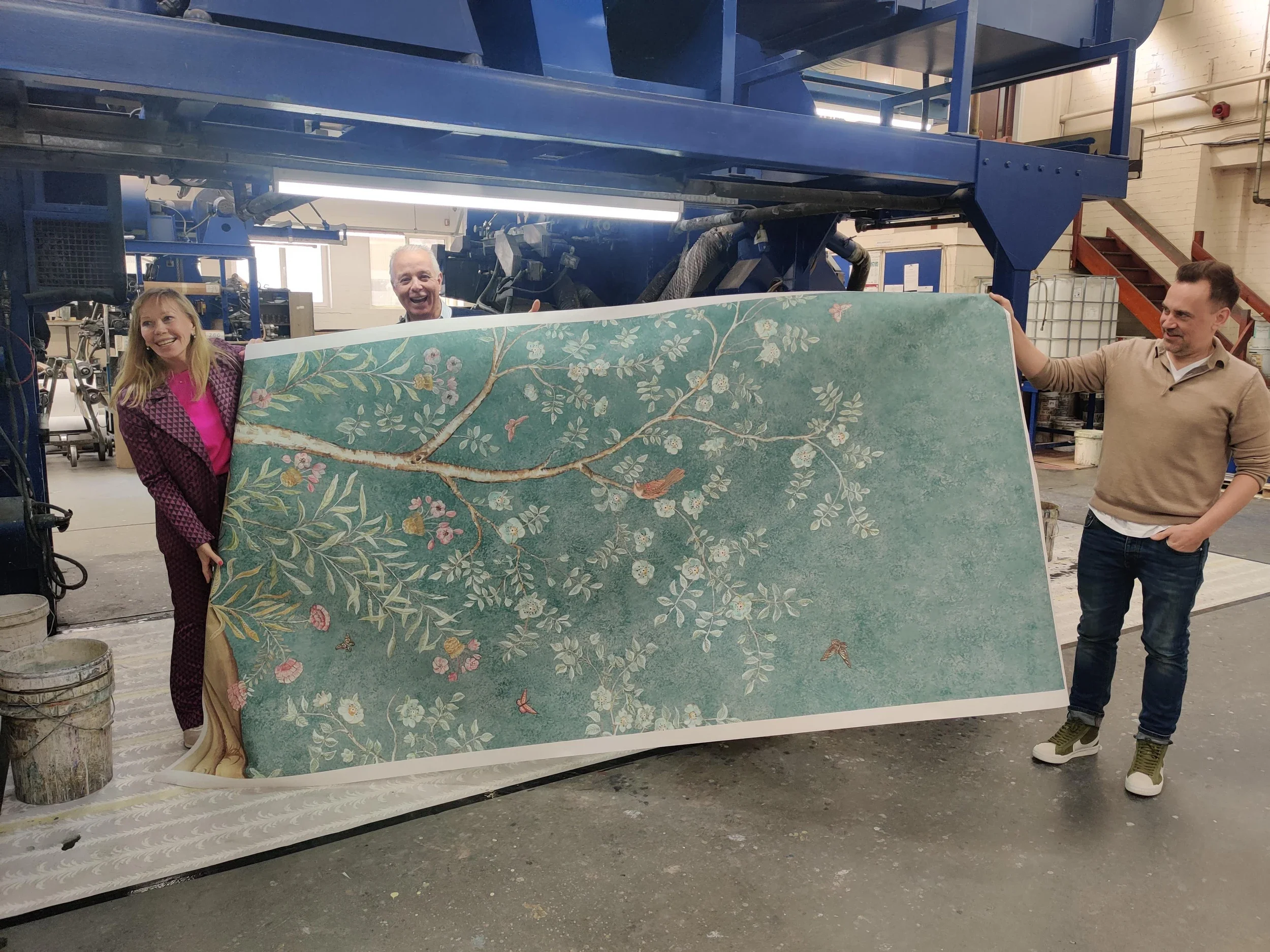 Kit Kemp and man at wallpaper factory holding Songbird wallpaper by Melissa White and Kit Kemp, also for Andrew Martin.