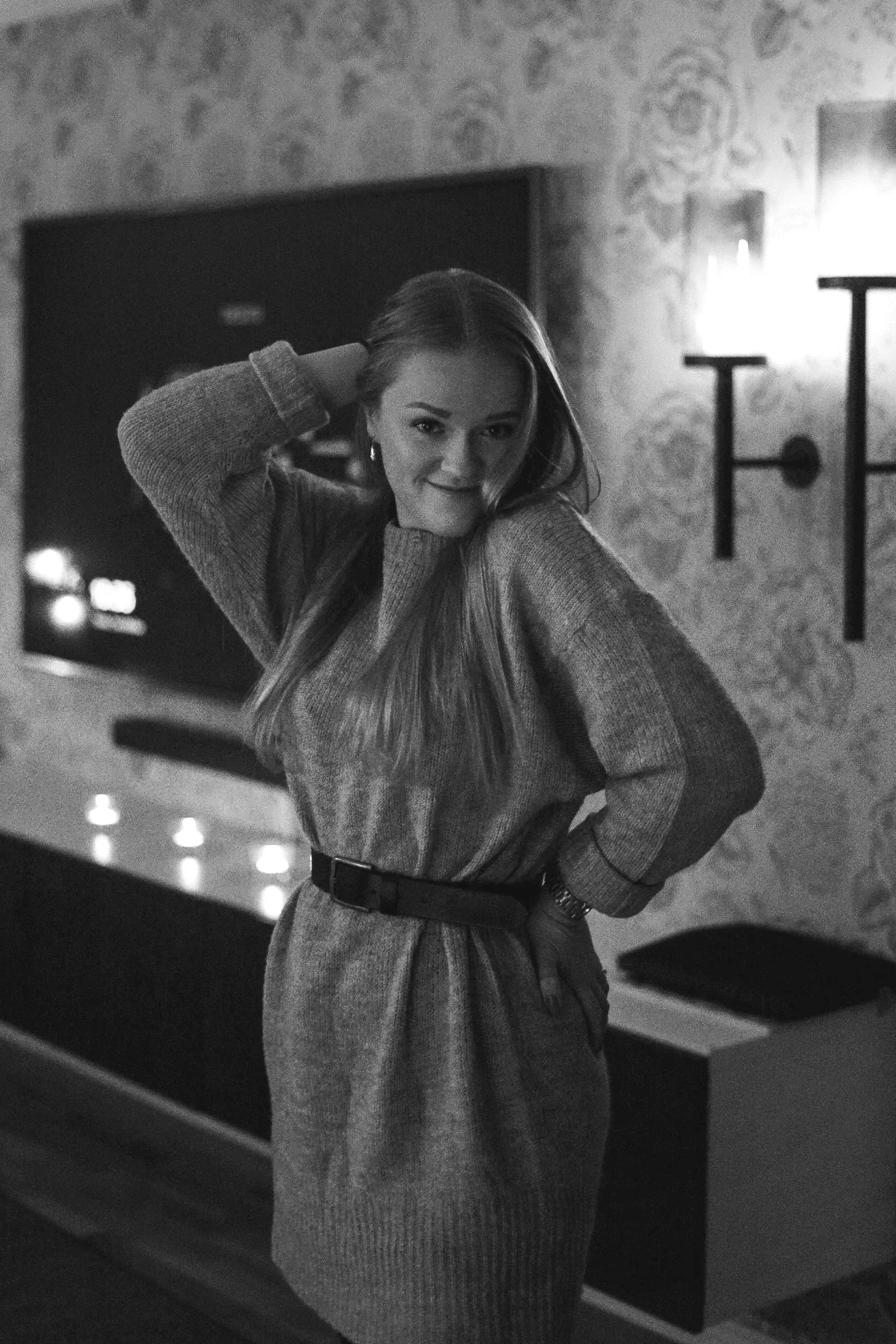 Matilda står i en klänning, och poserar glatt inomhus i ett vardagsrum.