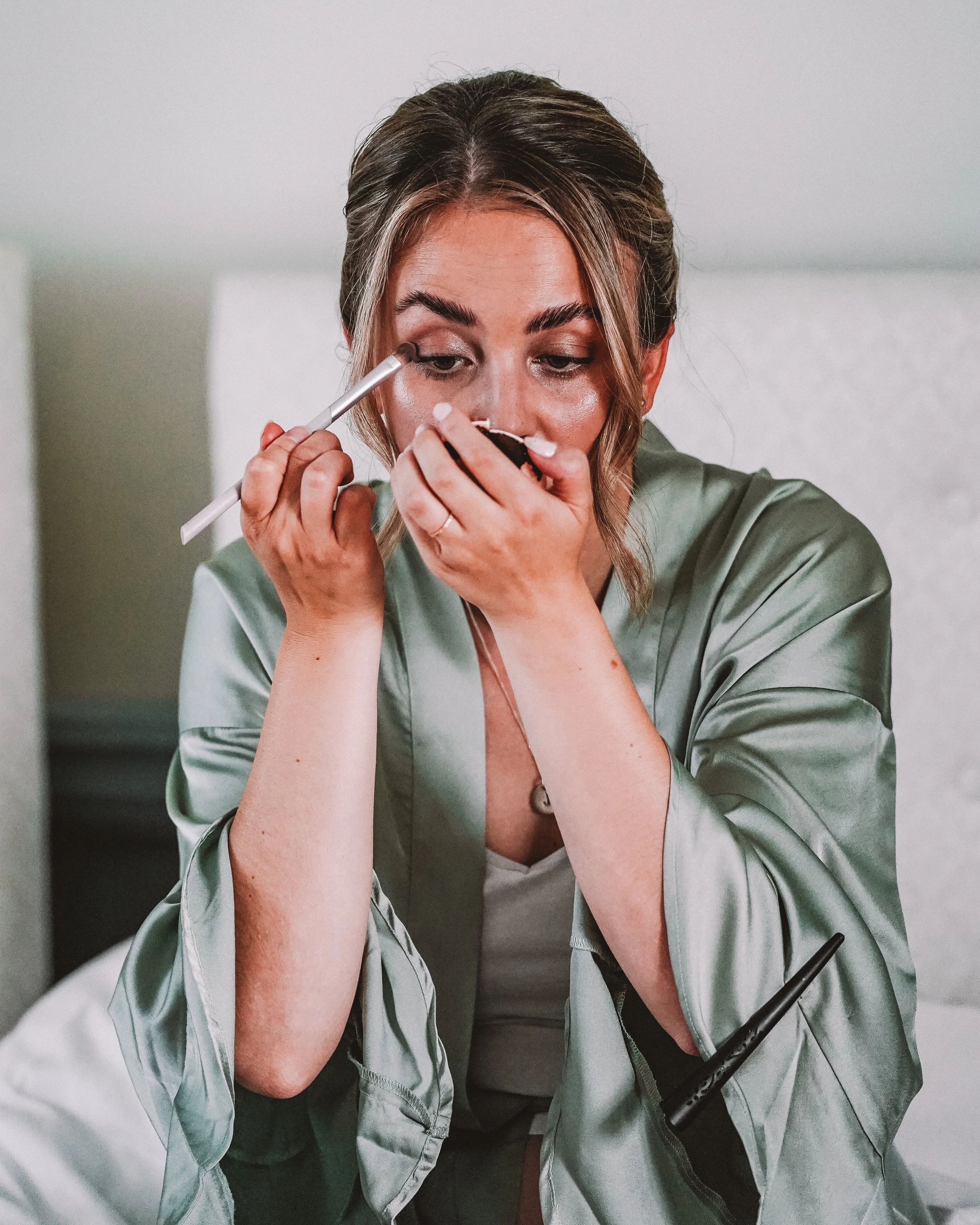 En kvinna applicerar ögonskugga med en borste.