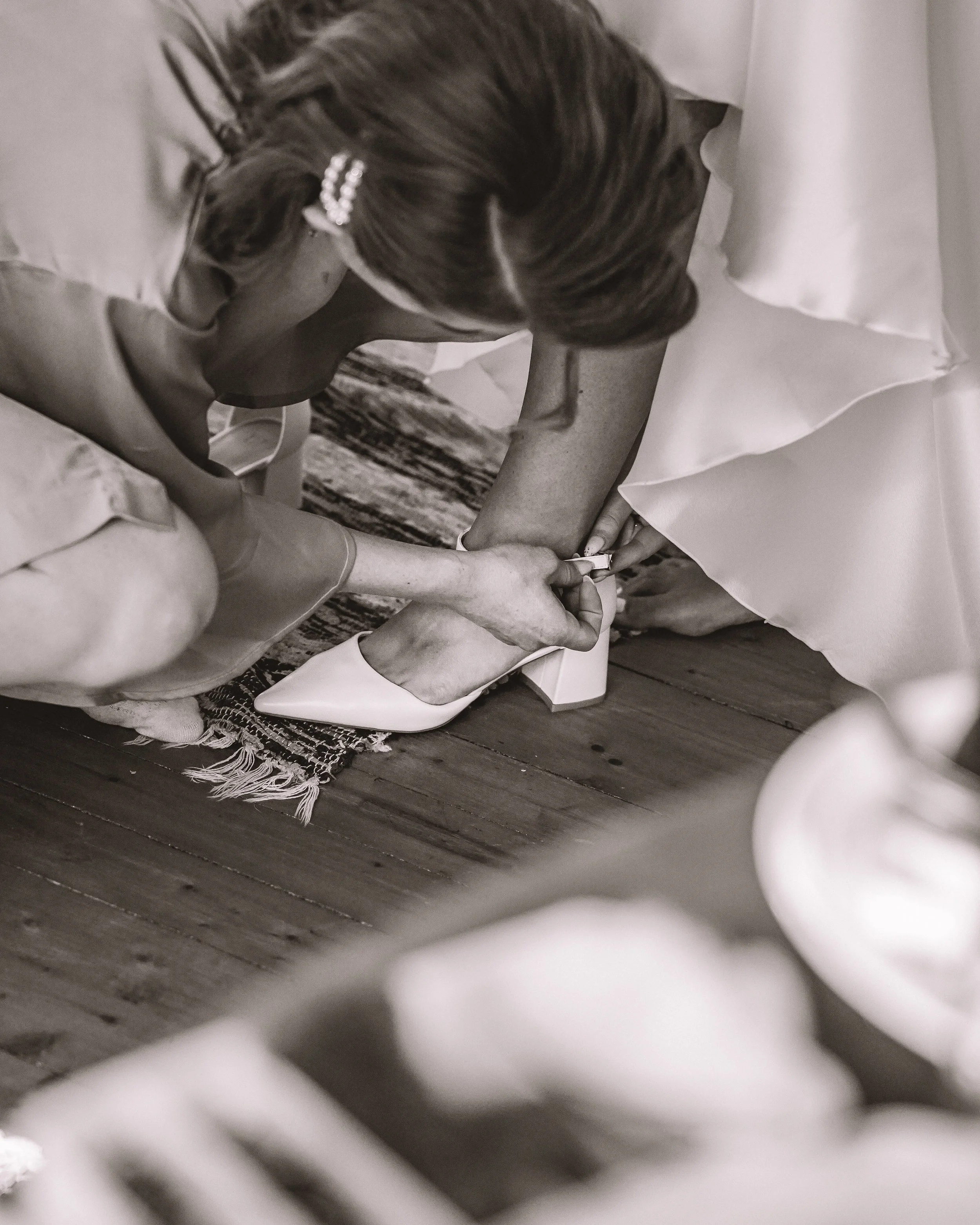 Brudparets skor och ett par hjälpare som arbetar för att säkra brudens skor.