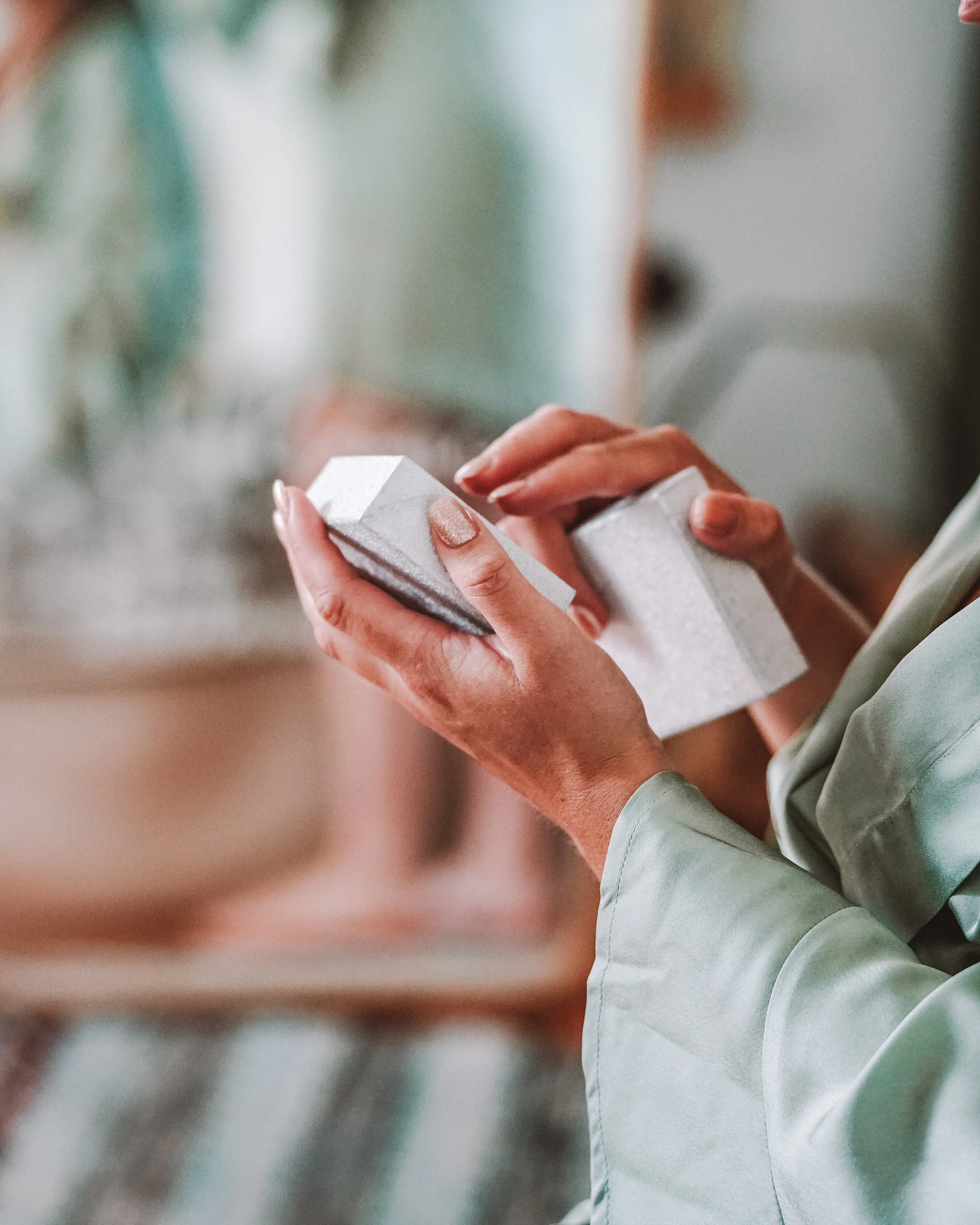 Nästan helkropp av person som håller ett vitt paket i handen i ett inomhusmiljö.