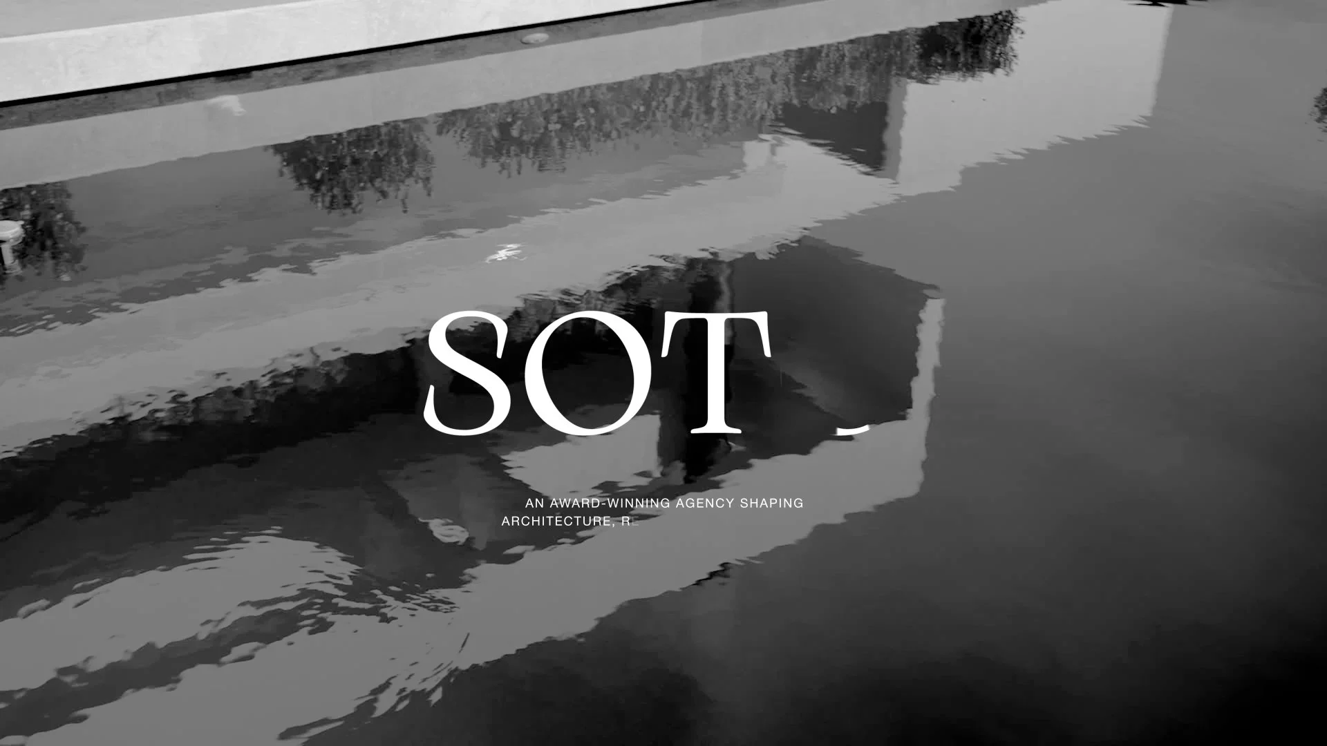 Black and white photo of a building and trees reflected in a body of water, with the word 'SOT' prominently displayed in the center and a phrase at the bottom reading 'An award-winning agency shaping architecture'.
