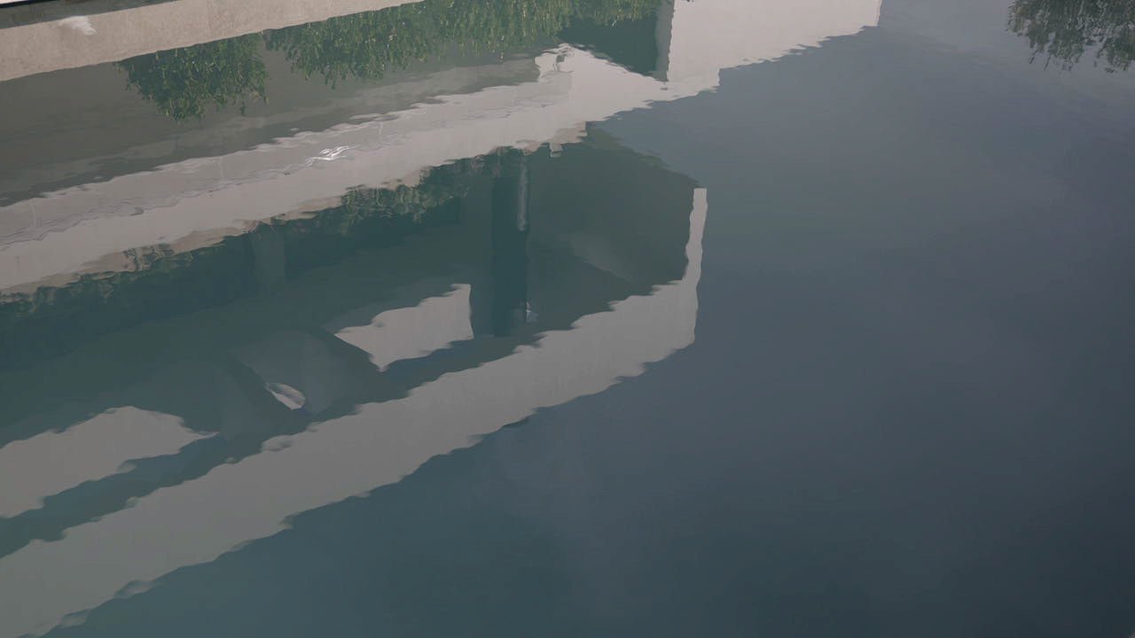 Reflection of a white structure and greenery in a body of water.