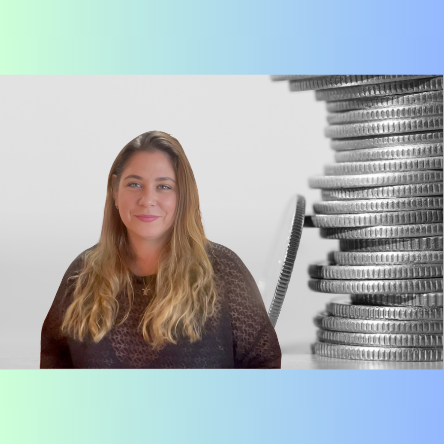 A smiling woman with long, wavy blonde hair, sitting in front of a large stack of coins.
