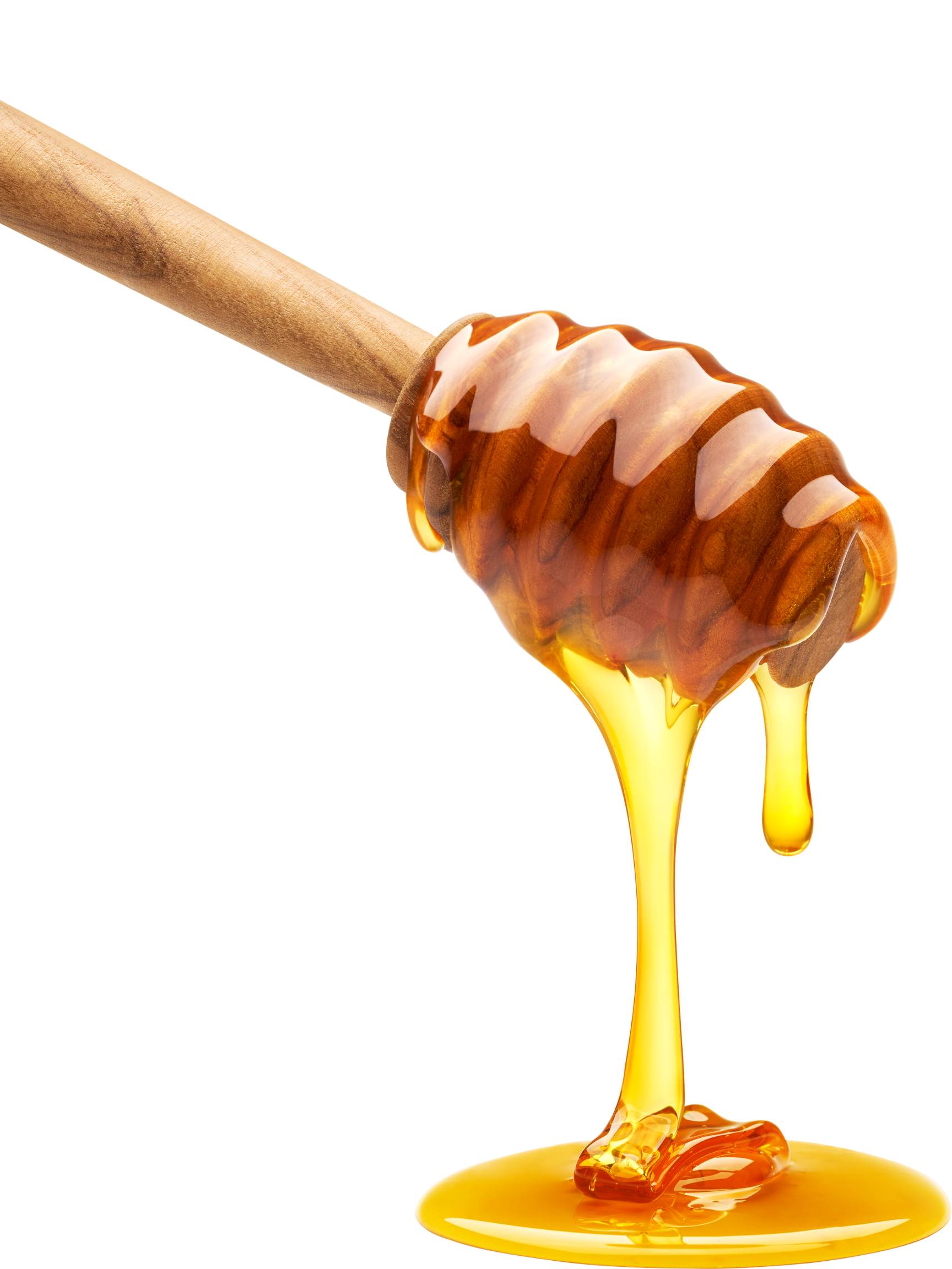 Honey being poured from a honey dipper onto a yellow surface.