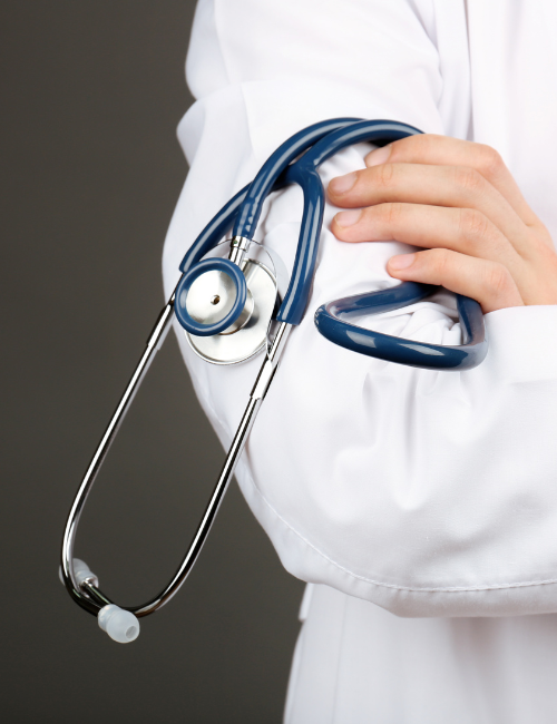 Doctor con bata blanca sosteniendo un estetoscopio azul.