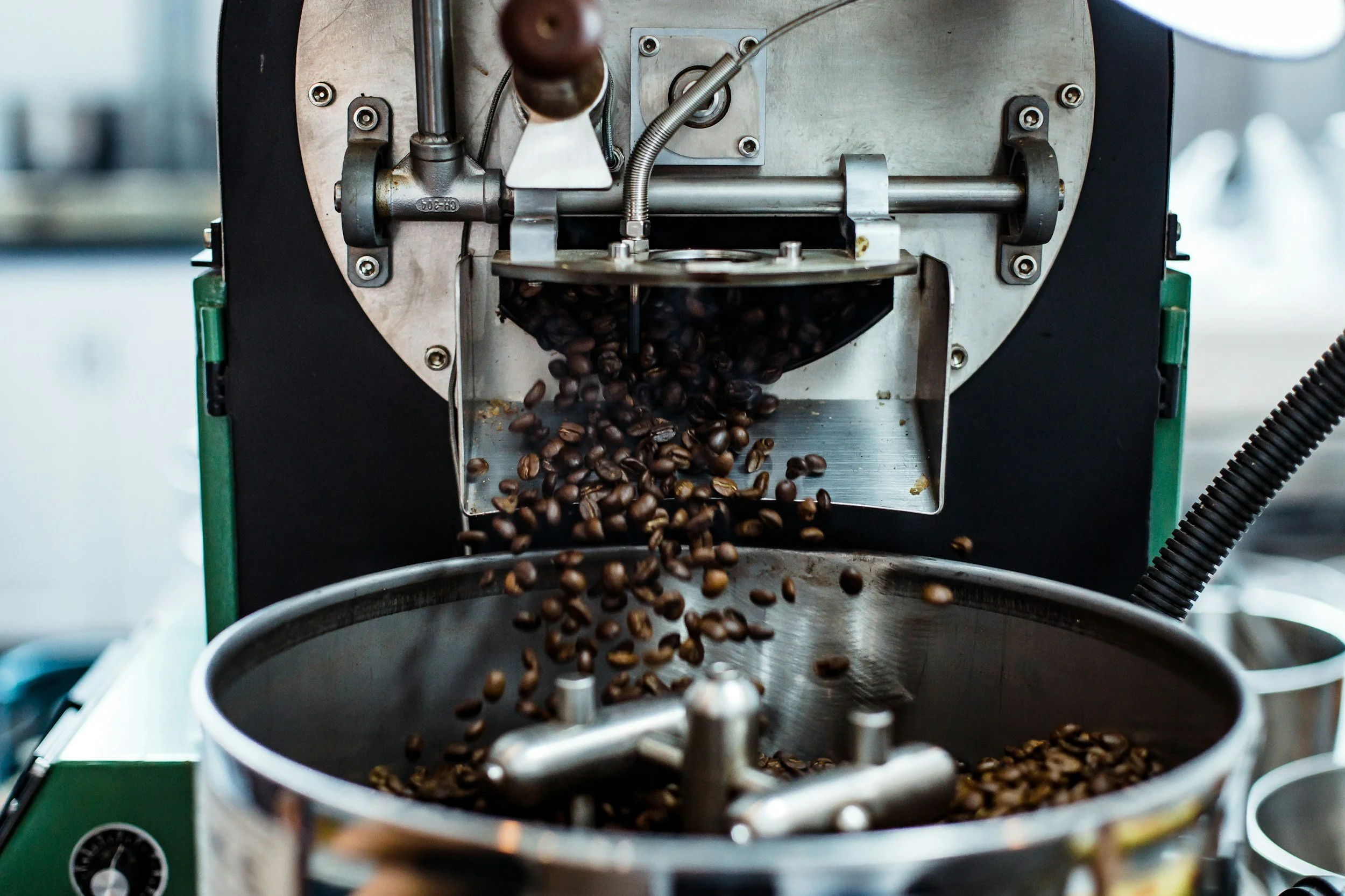 Coffee beans being roasted in a commercial coffee roaster machine.