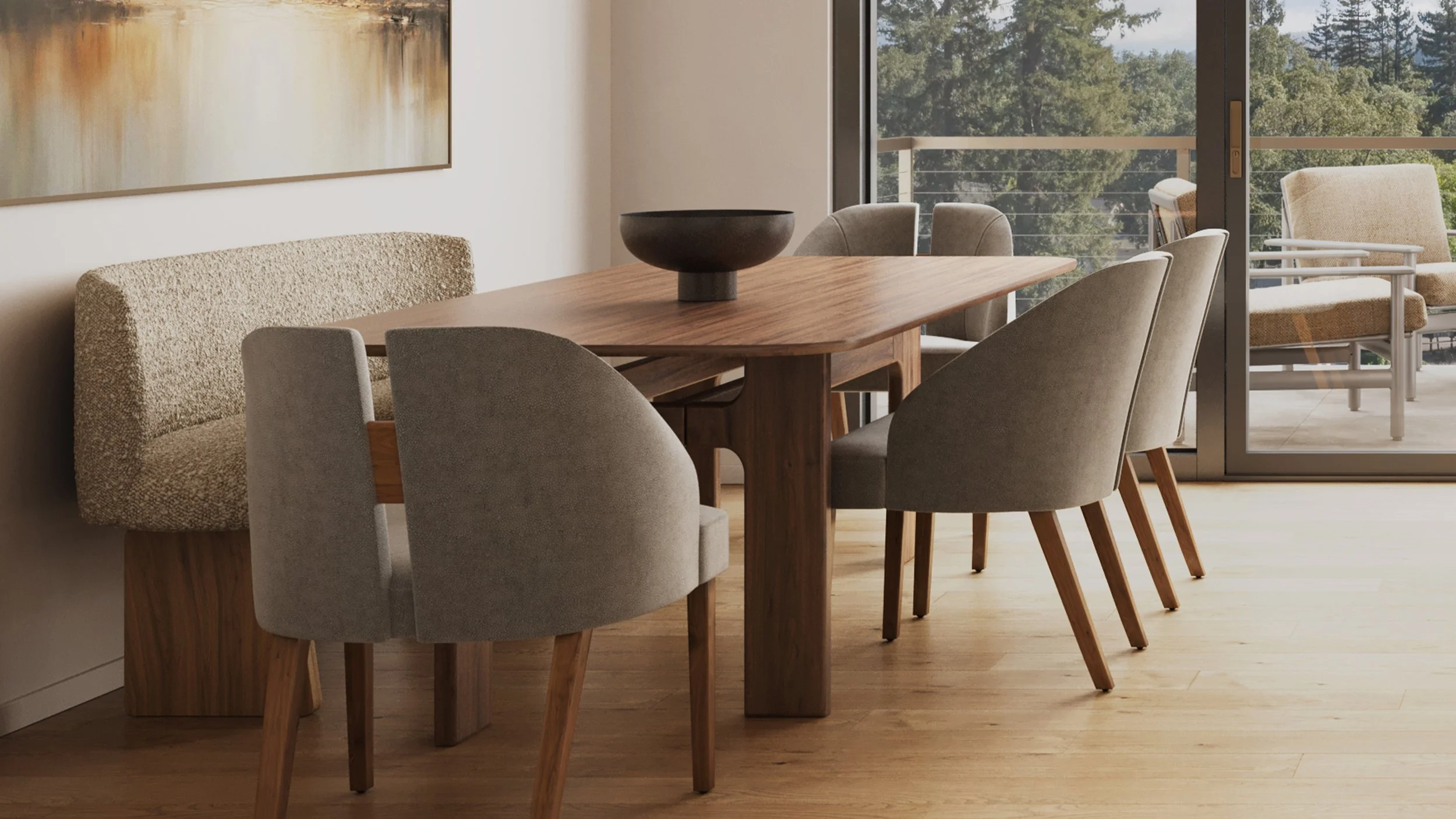 A dining room with a wooden table and six beige upholstered chairs, a black bowl on the table, abstract artwork on the wall, and large windows showing trees outside.