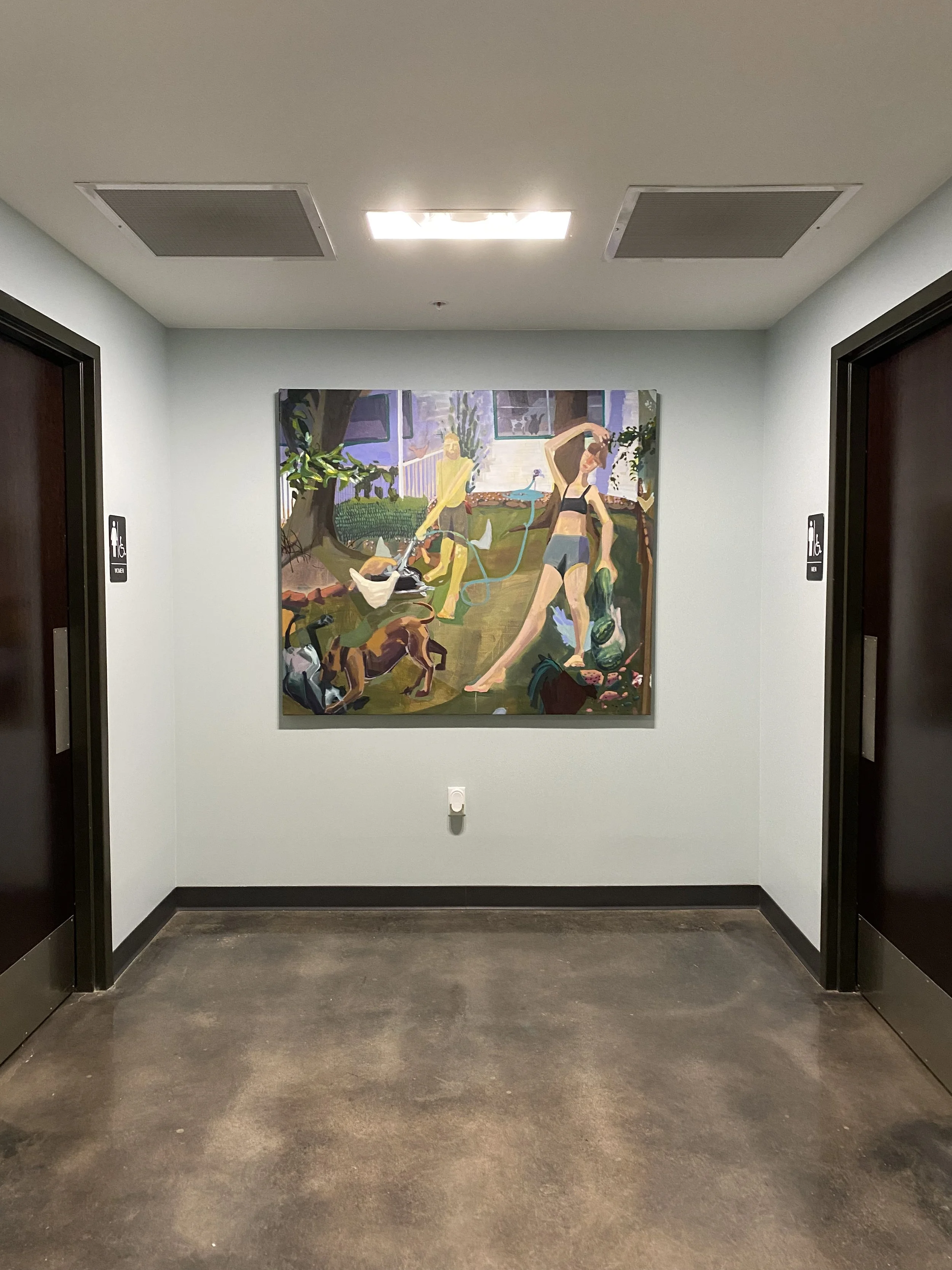 A hallway with a painting on the wall between two elevator doors, one labeled accessible. The floor is dark and the ceiling has fluorescent lights and ventilation panels.